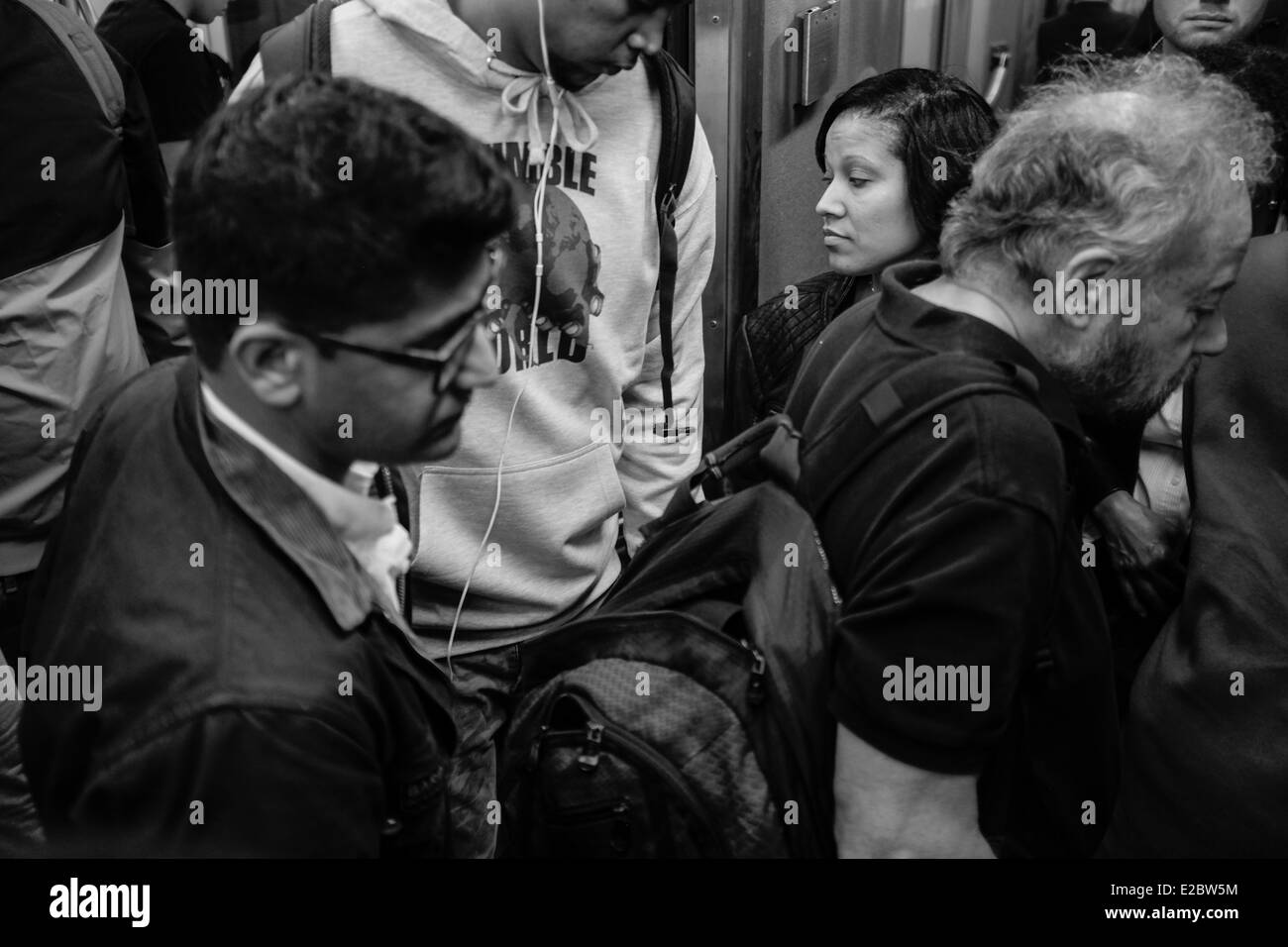 Passeggeri uscire ed entrare in un affollato vagone della metropolitana durante le ore di punta nella città di New York. Foto Stock