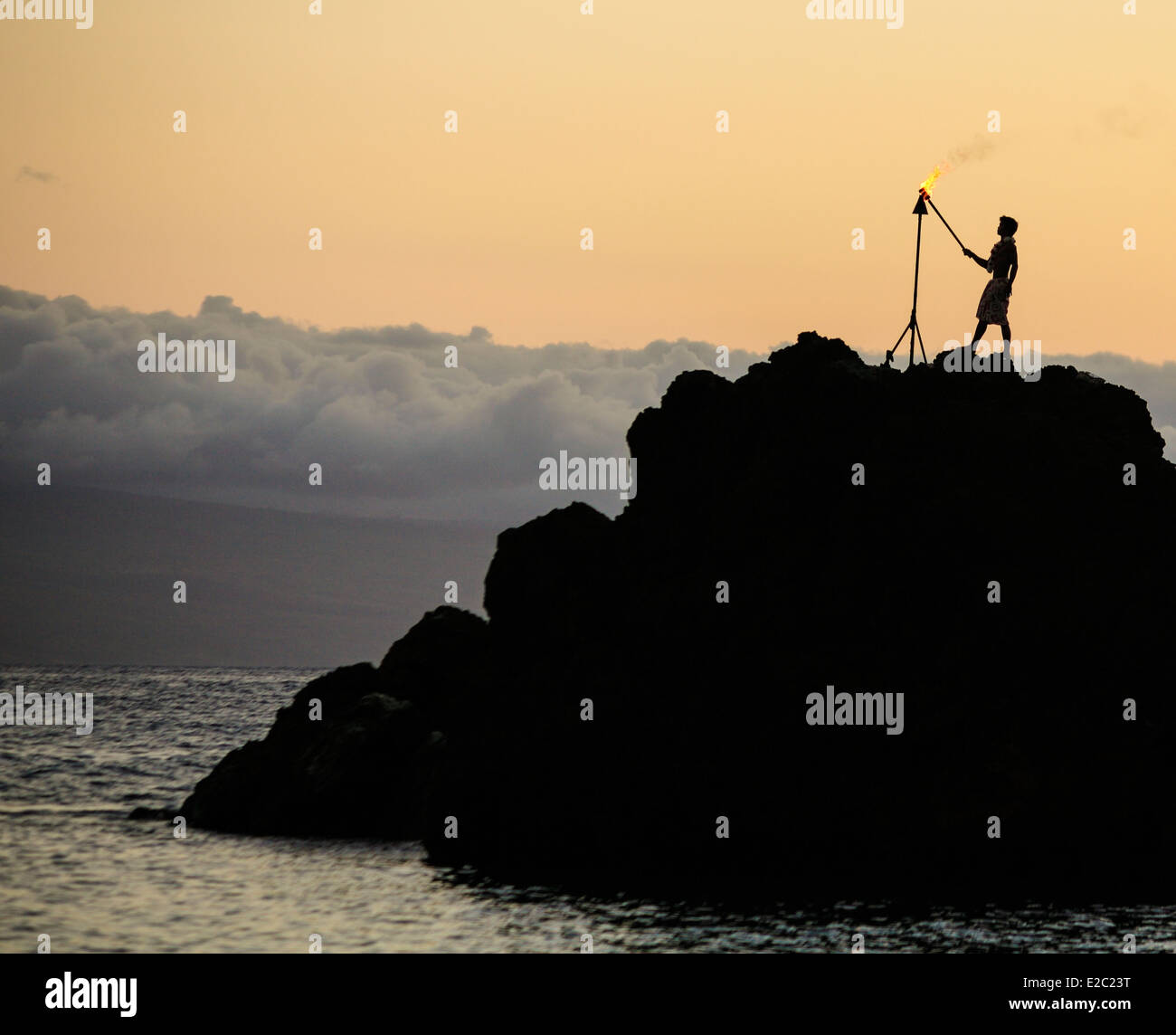Uomo torcia luci sulla roccia nera a Kaanapali Beach prima di immersioni subacquee cliff durante il tramonto visualizza Foto Stock