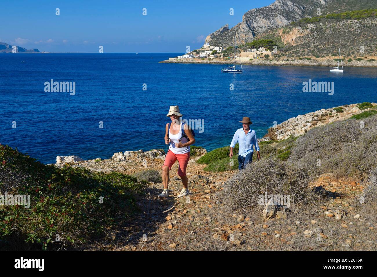 L'Italia, sicilia, isole Egadi, isola di Levanzo, Cala Fredda, gli escursionisti su un ripido sentiero al mare in background Foto Stock