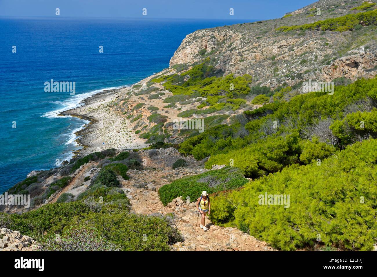 L'Italia, sicilia, isole Egadi, isola di Levanzo, shoal Faraglione, escursionista su un sentiero costiero affacciato sul mare verso la grotta Genovese Foto Stock