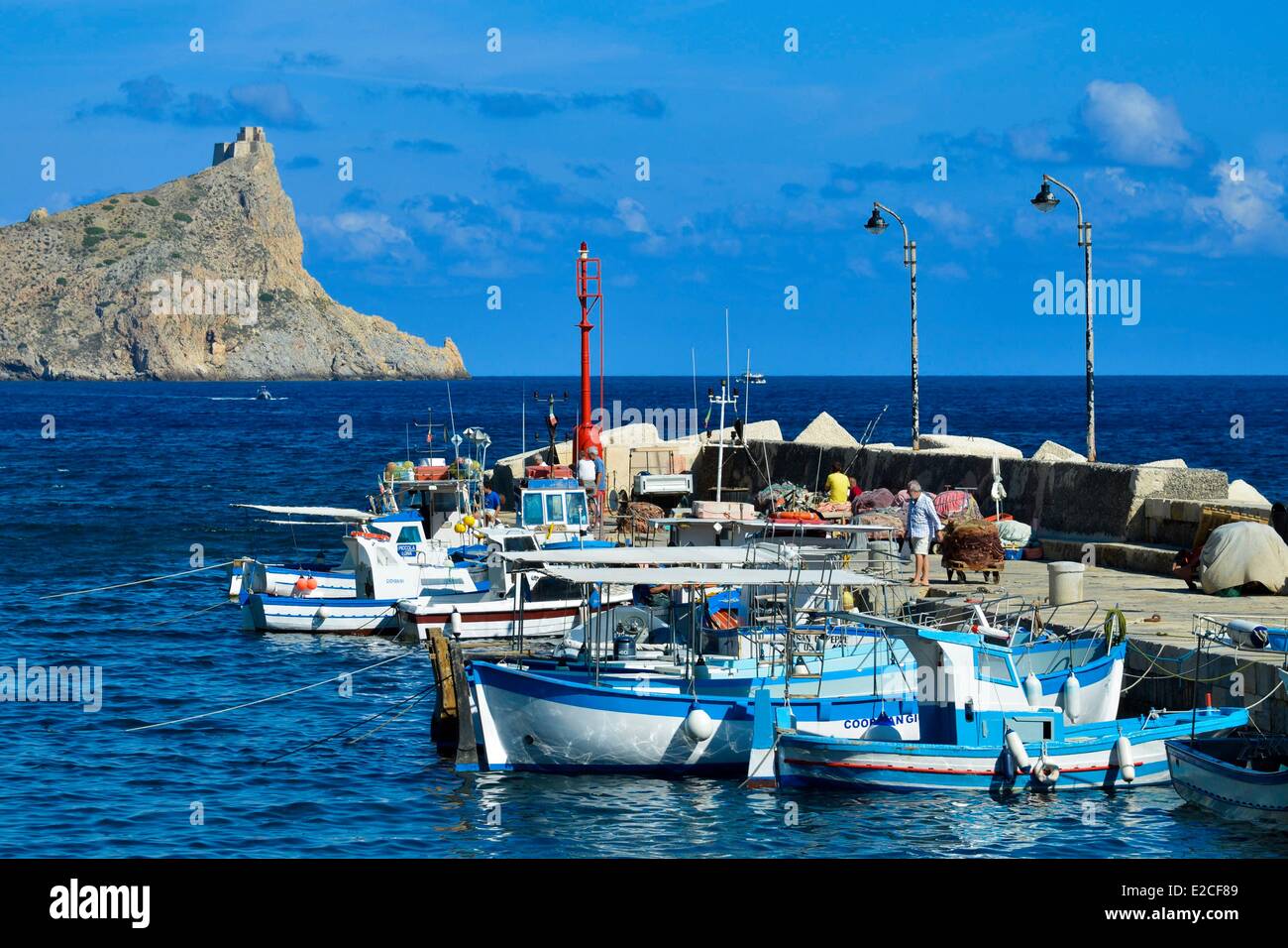 L'Italia, sicilia, isole Egadi, isola di Marettimo, porto di pesca, i pescherecci con reti da traino dock in legno con Punta Troia, castello in background Foto Stock