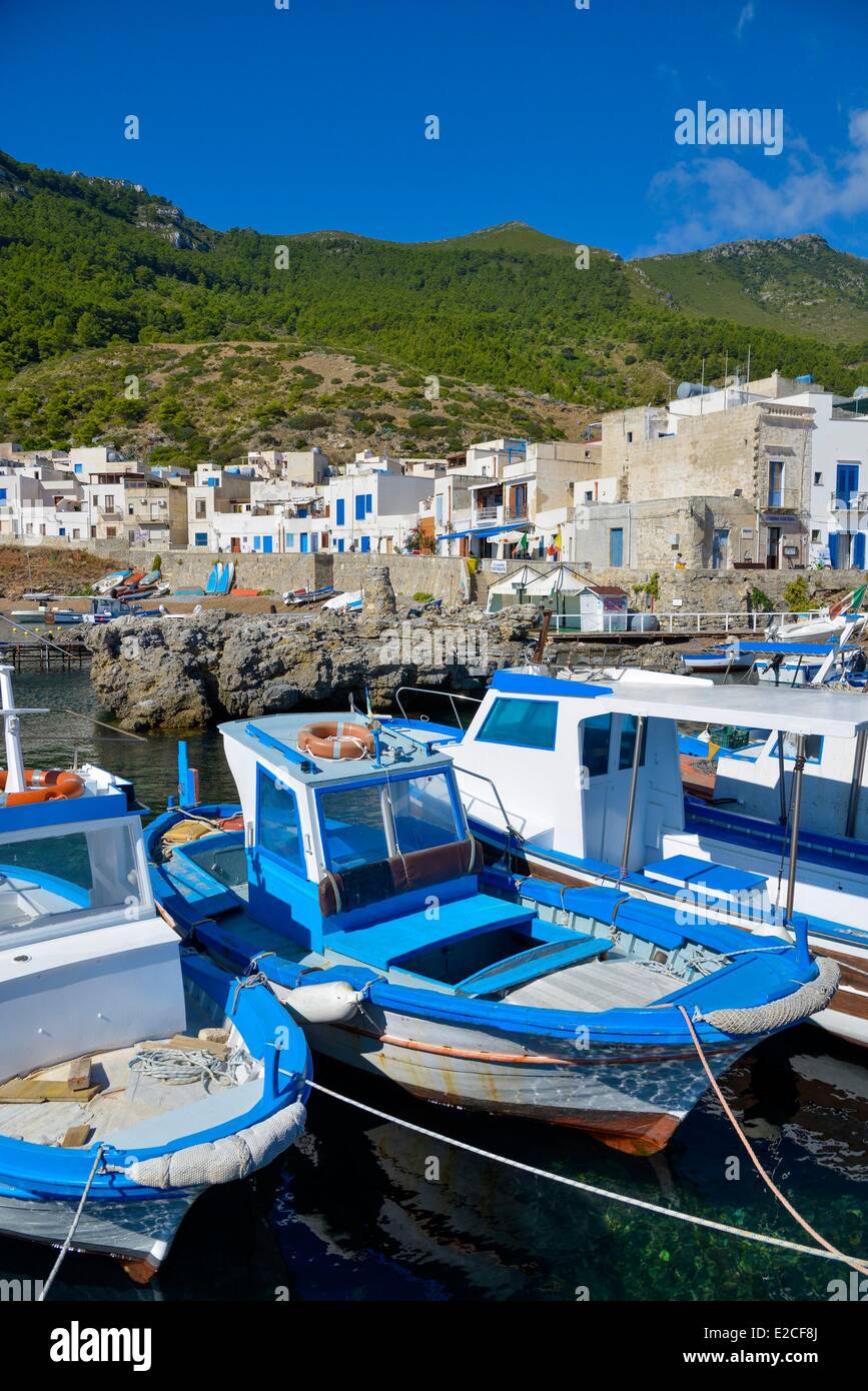 L'Italia, sicilia, isole Egadi, isola di Marettimo, colorate barche da pesca in porto con case di città piazze e pareti dipinte di bianco in background Foto Stock
