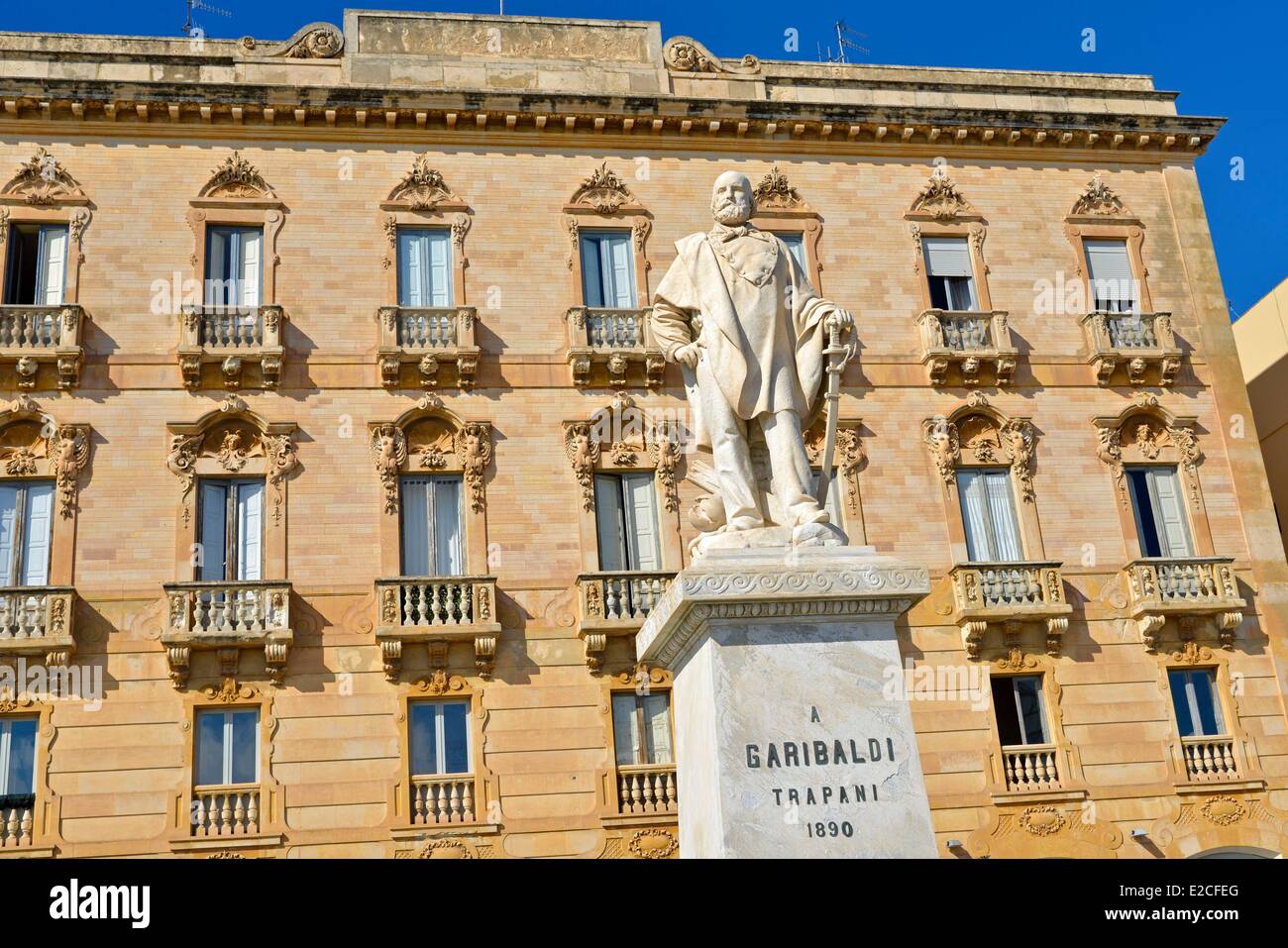 L'Italia, Sicilia, Trapani, centro storico, statua di Garibaldi con un edificio in pietra in background Foto Stock