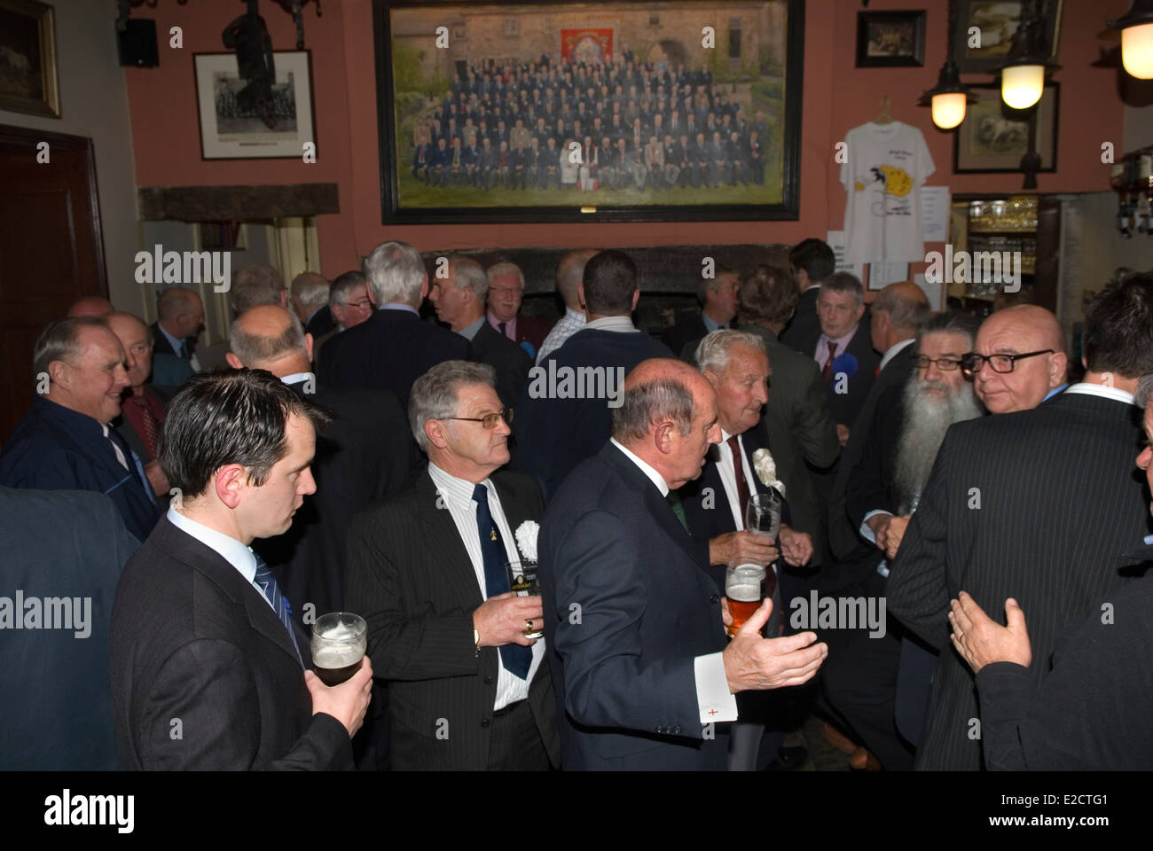 Askrigg Friendly Society, membri del bar del Kings Arms Hotel prima della passeggiata annuale fino alla chiesa dietro lo striscione della Askrigg Friendly Society. I membri onorari indossano una rosetta bianca, mentre i membri ordinari ne indossano una blu. Askrigg, North Yorkshire, Inghilterra 5 giugno 2014 2010s UK HOMER SYKES Foto Stock