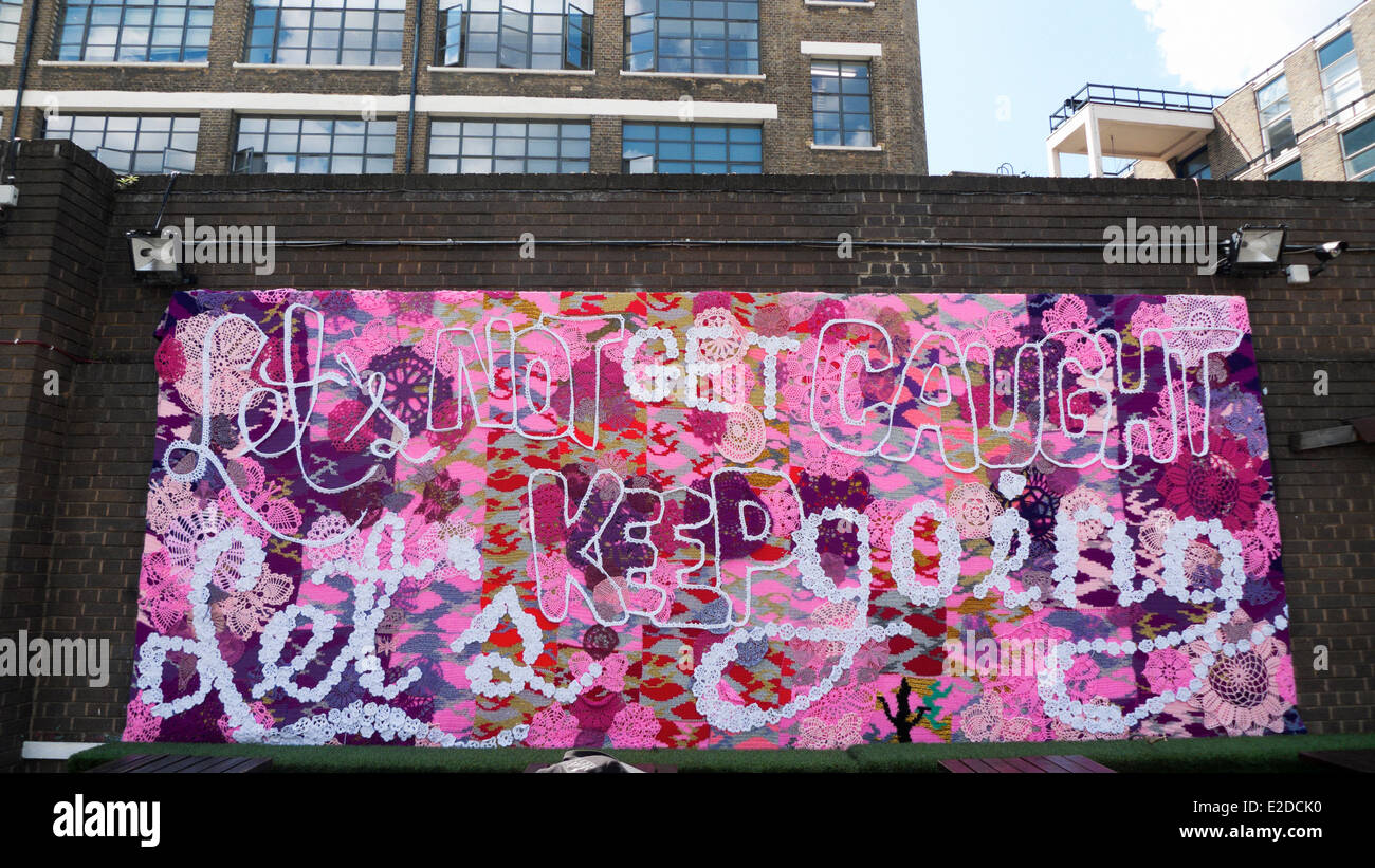 Tabellone a mano Olek street art 'Cerchiamo di non restare impigliati Teniamoci andando' Brick Lane in Shoreditch London E2 KATHY DEWITT Foto Stock