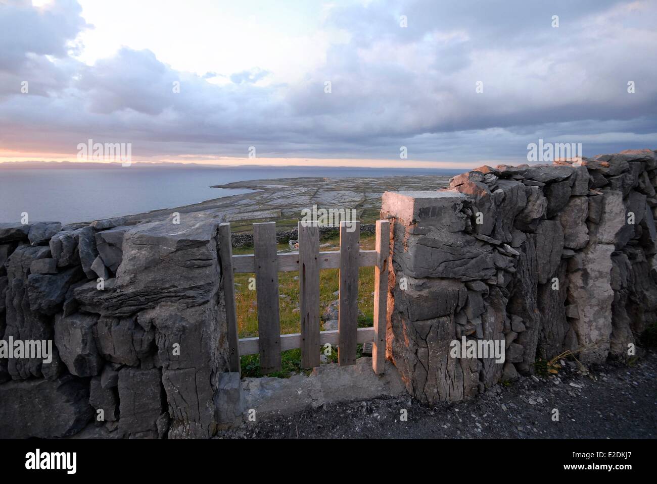 L'Irlanda County Galway Isole Aran Inishmaan stalattite parete della Baia di Galway Connemara montagne sullo sfondo di legno al tramonto Foto Stock