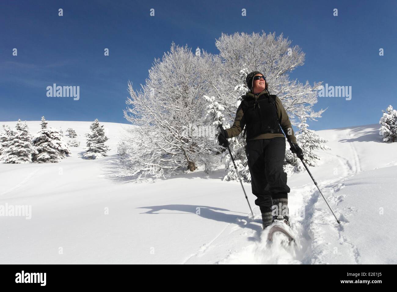 Francia Isere Vercors riserva naturale nazionale con le racchette da neve escursionista femmina sopra il villaggio Foto Stock