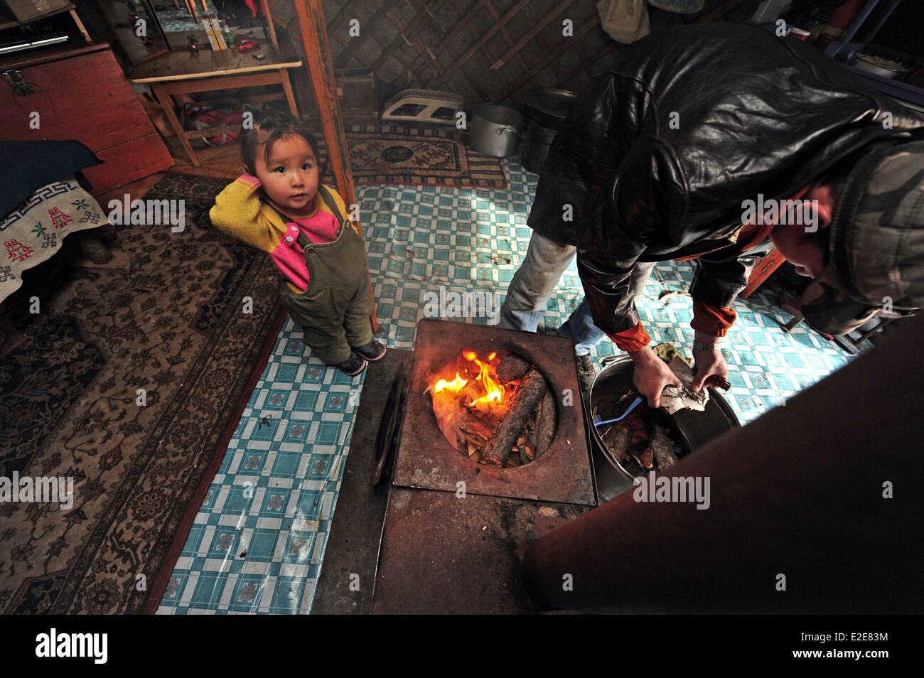 Mongolia, Tov provincia, Baganuur, padre in piedi dalla figlia, tenendo registro da camino in yurta Foto Stock