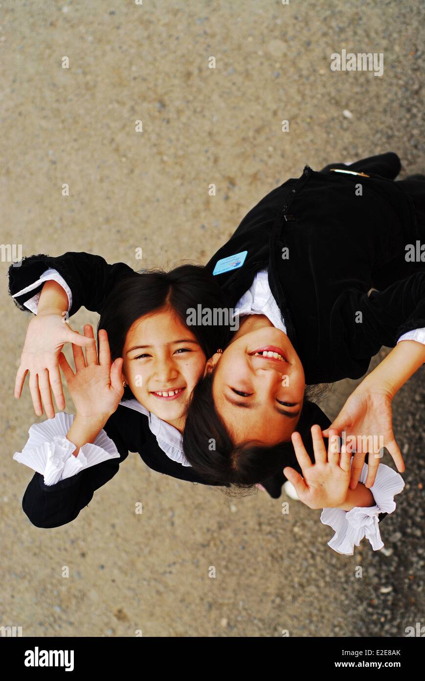 Uzbekistan, Fergana, vista in elevazione delle ragazze sorridenti con gesti con le mani Foto Stock