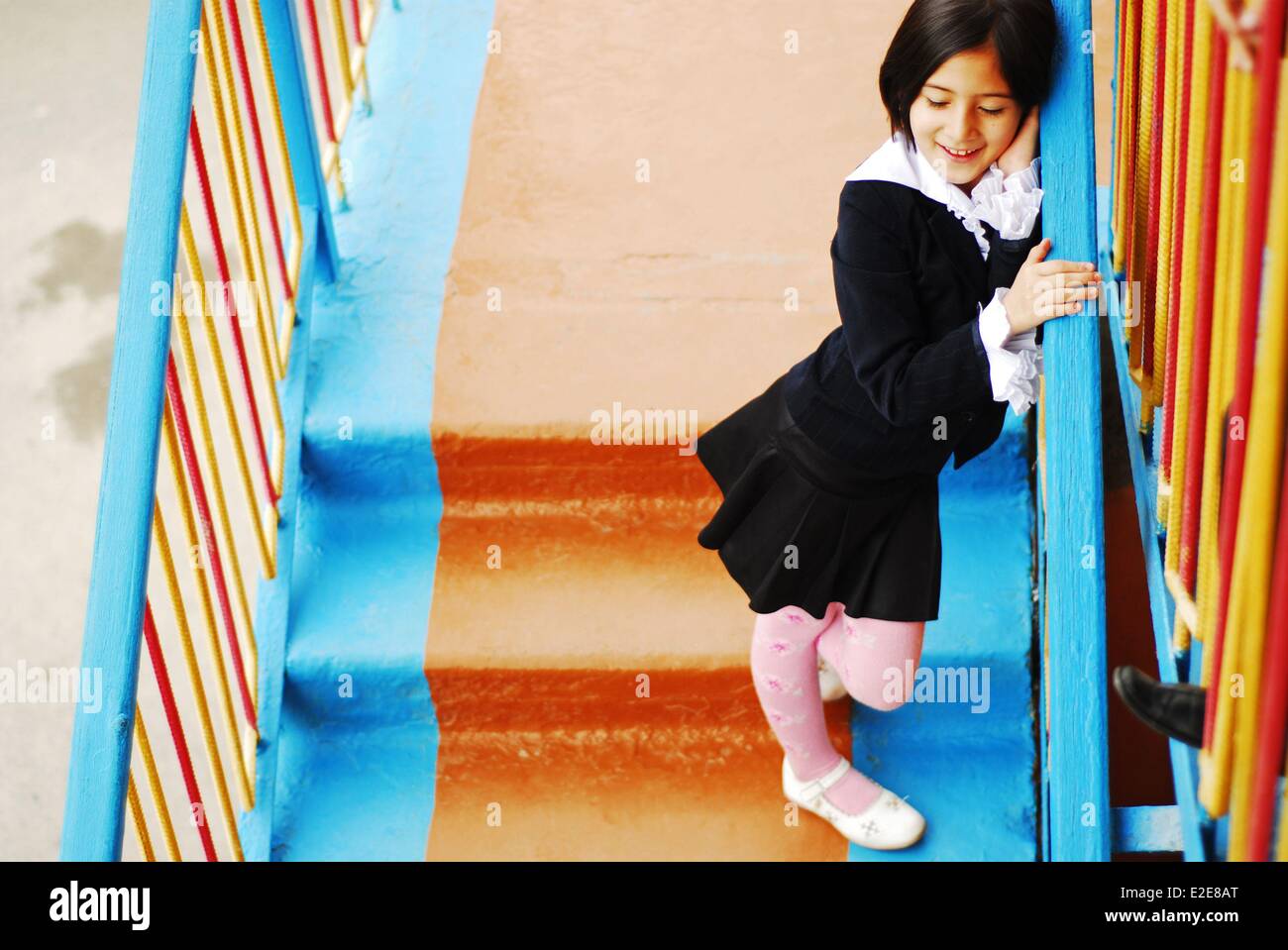 Uzbekistan, Fergana, vista in elevazione della ragazza sorridente in piedi sulle scale Foto Stock
