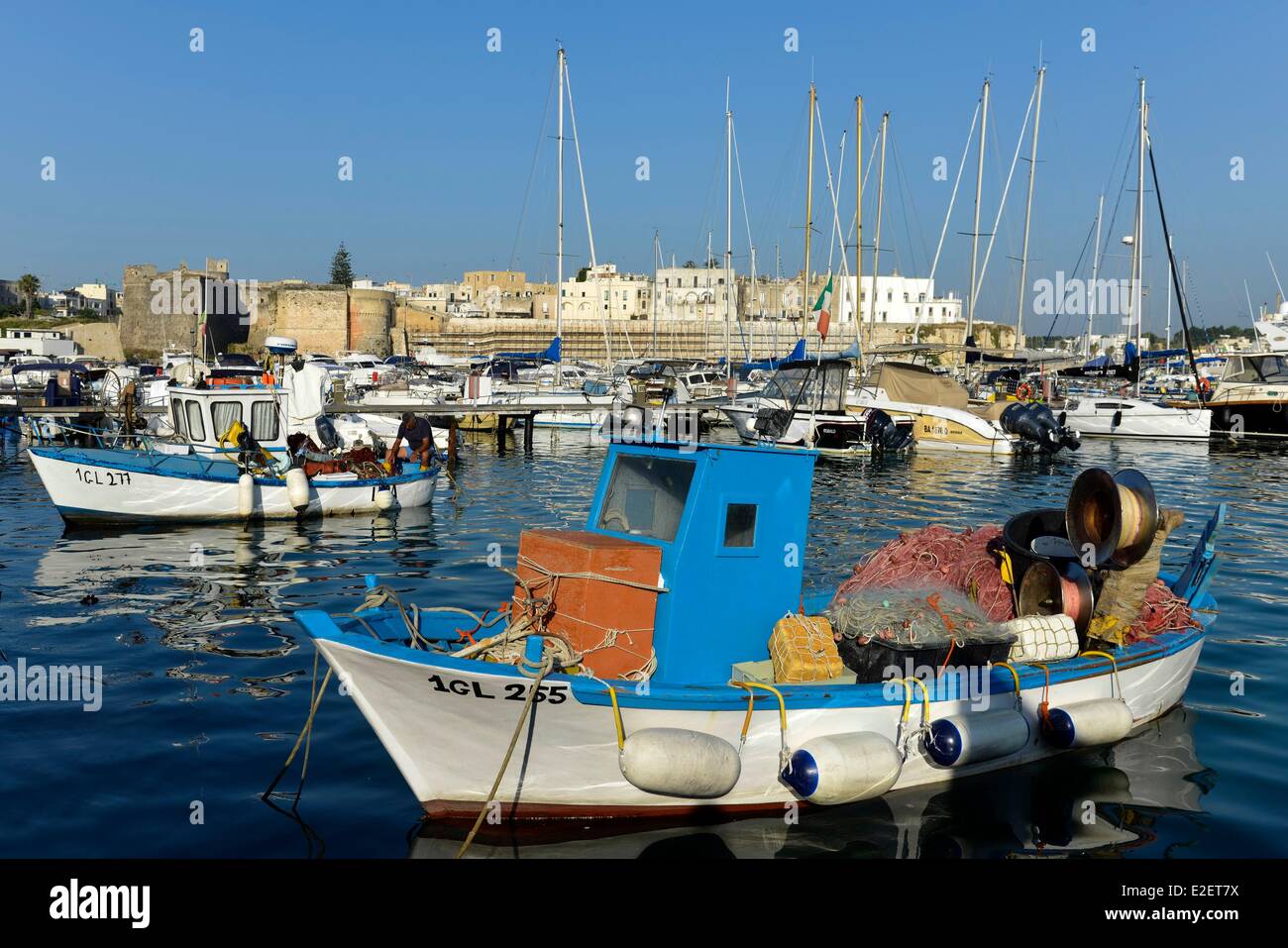 Italia Puglia Provincia di Lecce, Otranto, Marina, blu piccola barca da pesca riempito con reti con lo sfondo storico Foto Stock