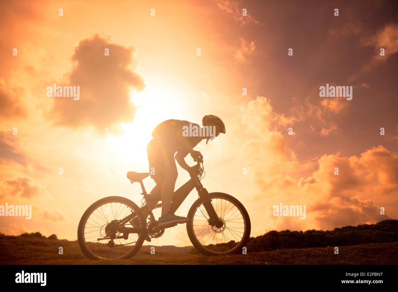 La silhouette di mountain bicycle rider sulla collina Foto Stock