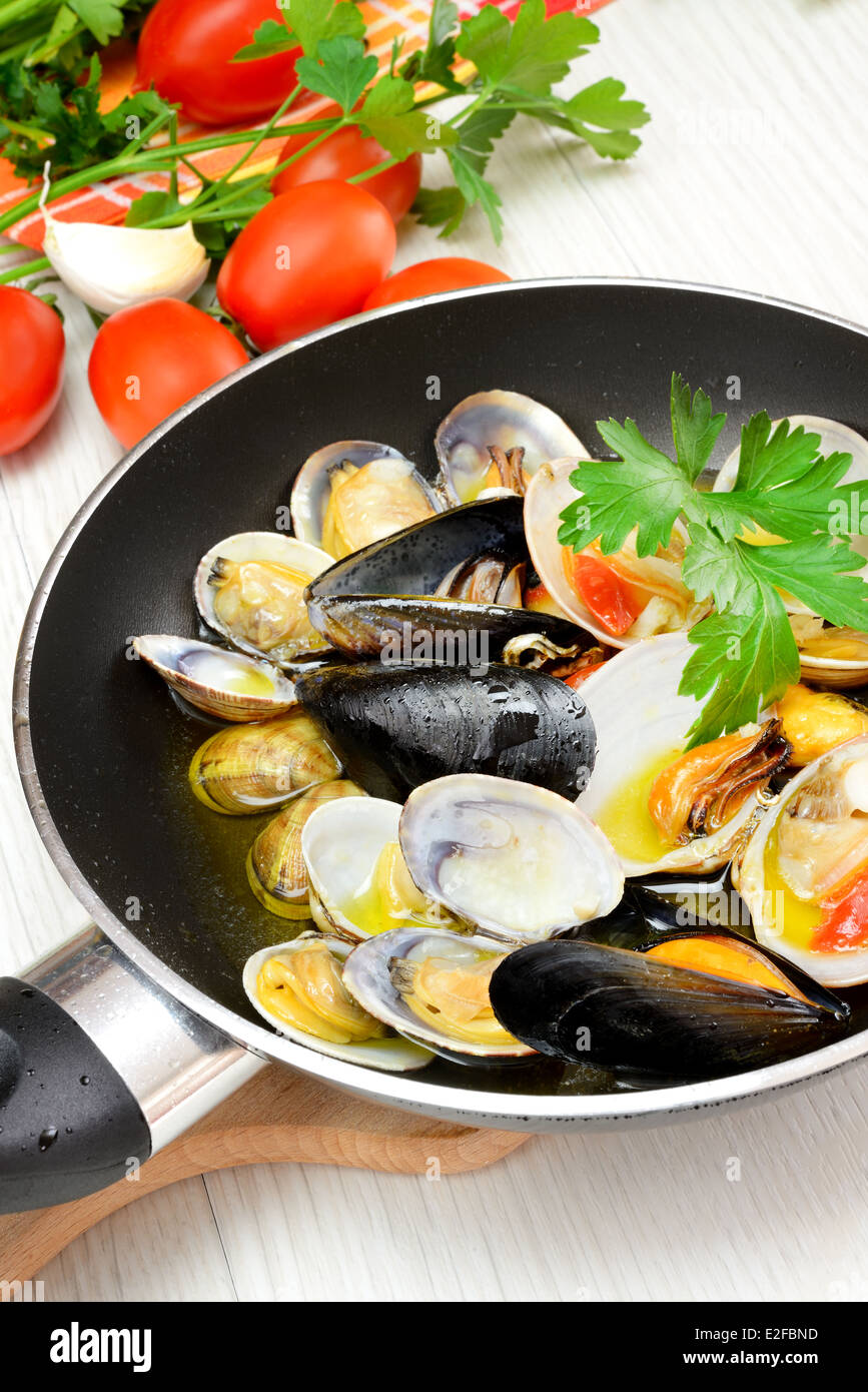 Il Saute frutti di mare in una padella con olio di oliva e prezzemolo Foto  stock - Alamy