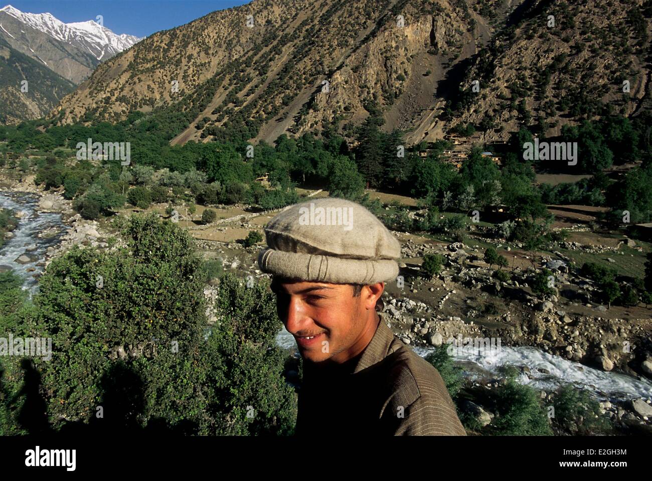 Il Pakistan Khyber Pakhtunkhwa Kalash valli Bumburet valle del fiume Bumburet Krakal village (2 150 m) nascosta dietro di lecci e alberi di gelso a monte della valle con cime innevate sullo sfondo dell'Afghanistan una giornata a piedi Foto Stock