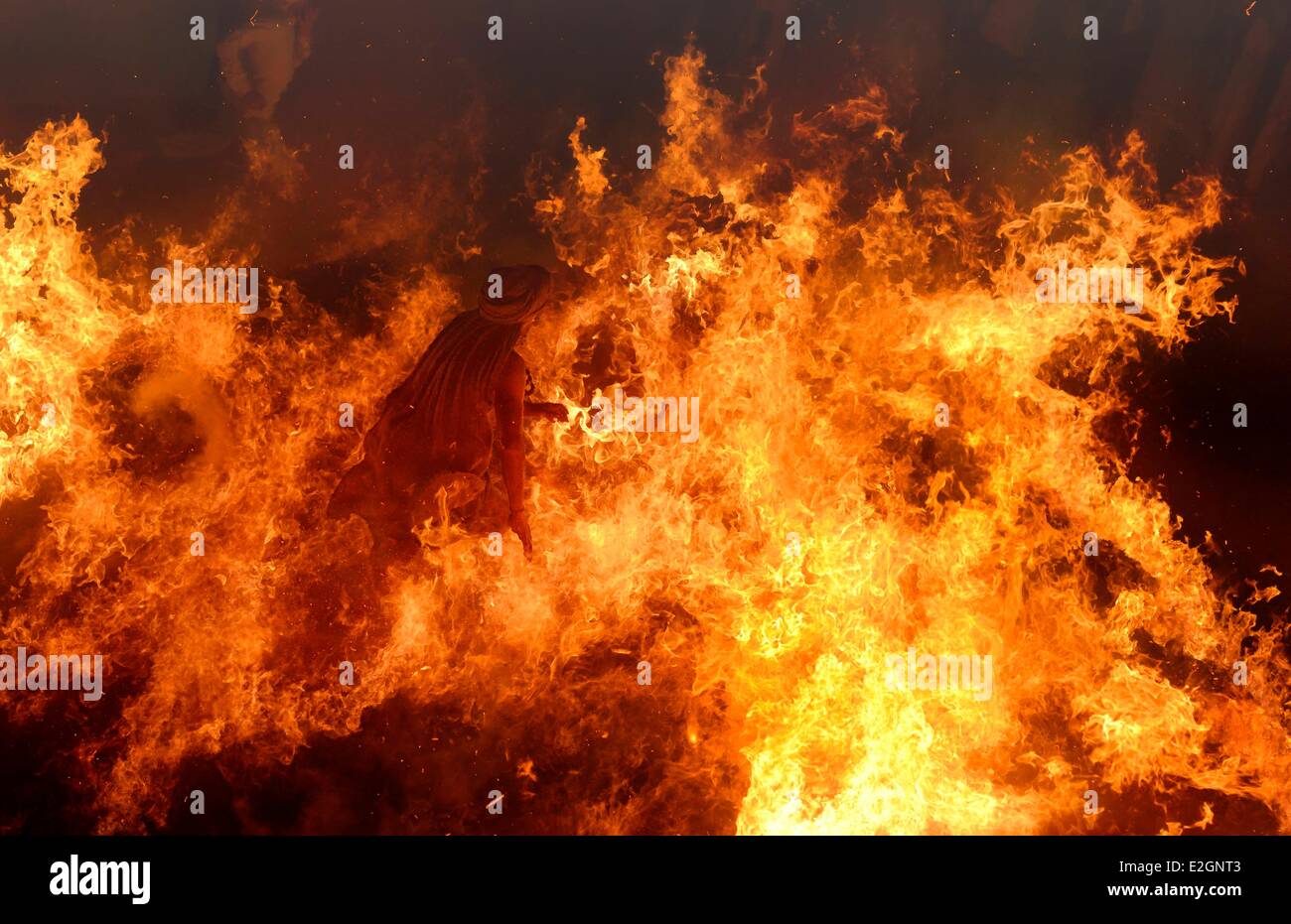India nello Stato di Uttar Pradesh un uomo saggio attraversa a piedi nudi un immenso incendio che egli esce illeso Foto Stock
