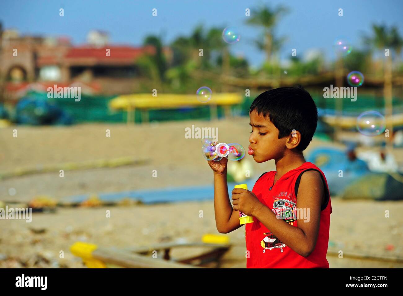 India Odisha membro Puri little boy soffiare bolle sulla spiaggia Foto Stock