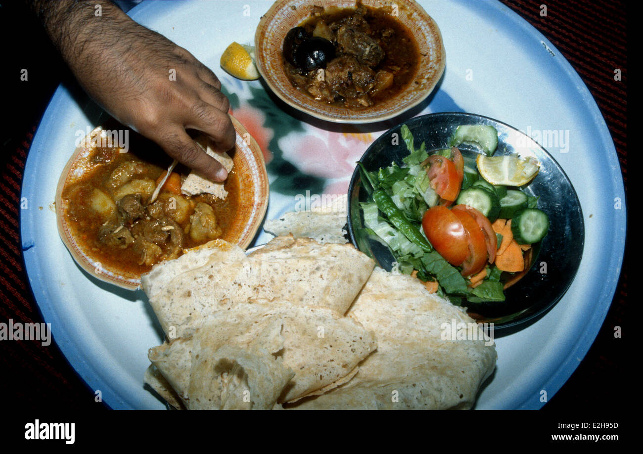 Gli arabi utilizzare la mano destra per mangiare piatti tradizionali di cibo Foto Stock