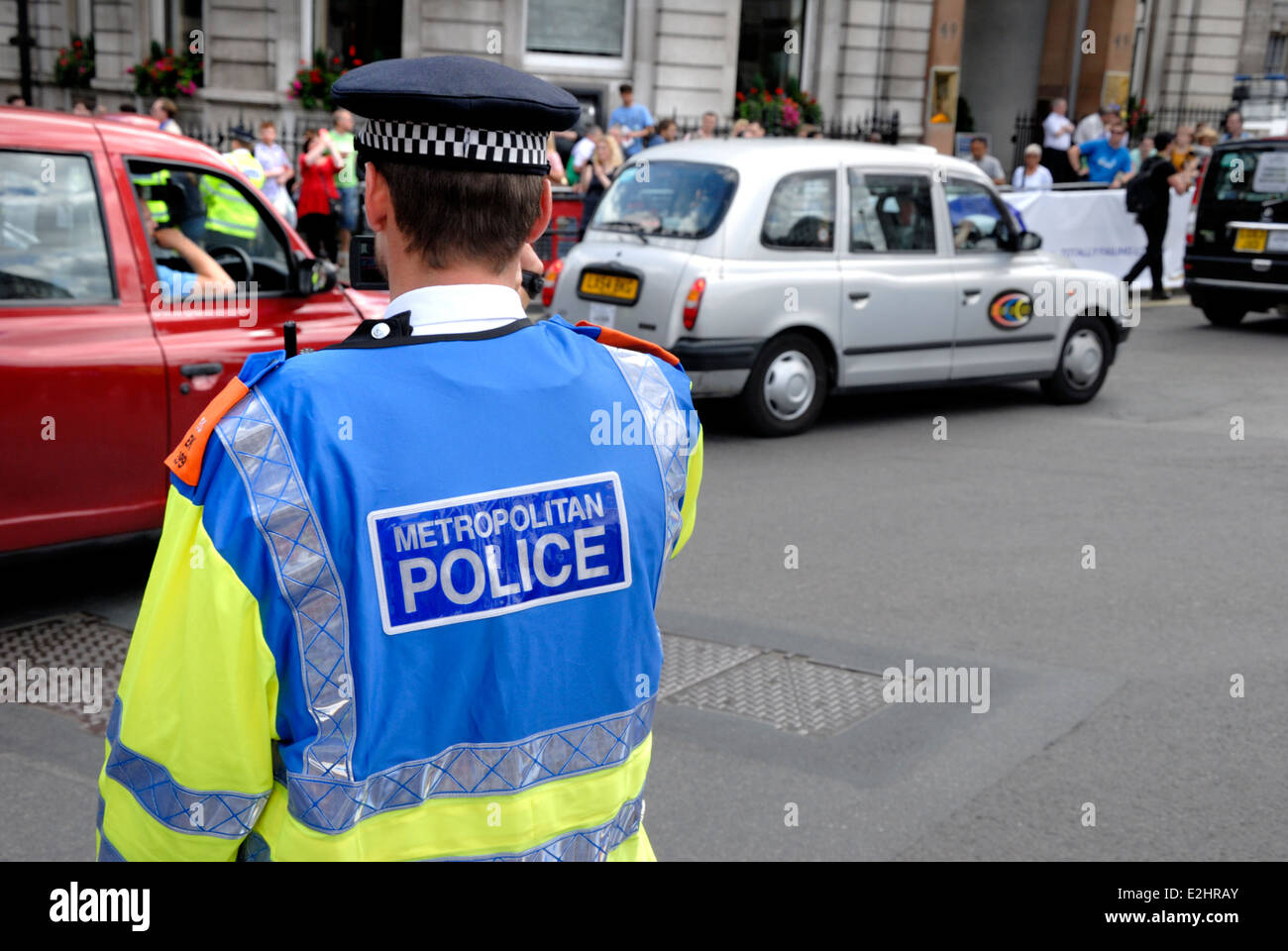 Londra, Inghilterra, Regno Unito. La Metropolitan police officer con hi-vis camicia durante una manifestazione di protesta da conducenti di taxi in centro a Londra, 2014 Foto Stock