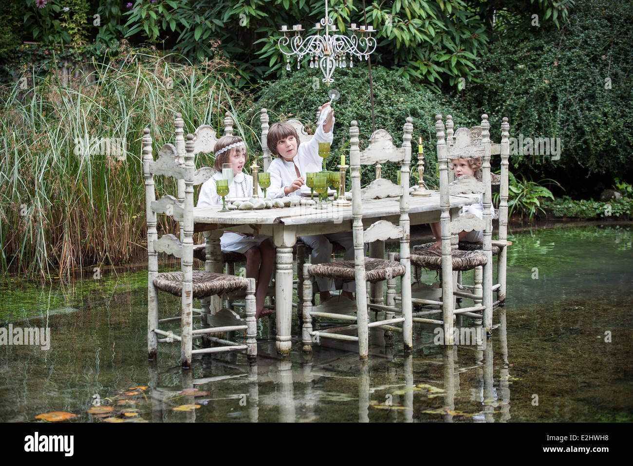 I bambini seduti a ornato tavolo da pranzo galleggiante sul lago Foto Stock