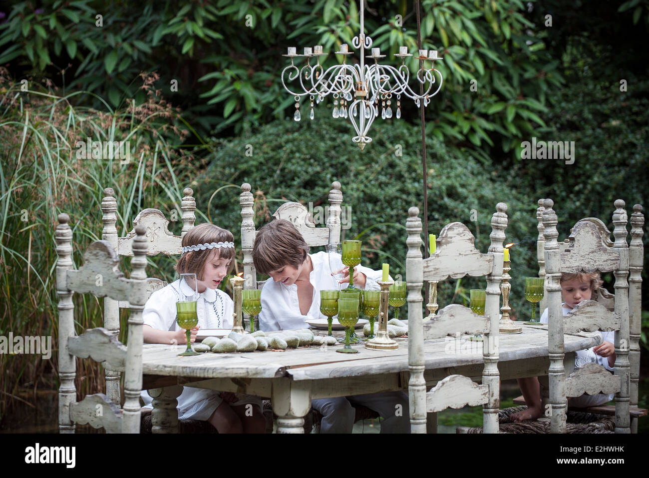 I bambini seduti a ornato tavolo da pranzo all'aperto Foto Stock