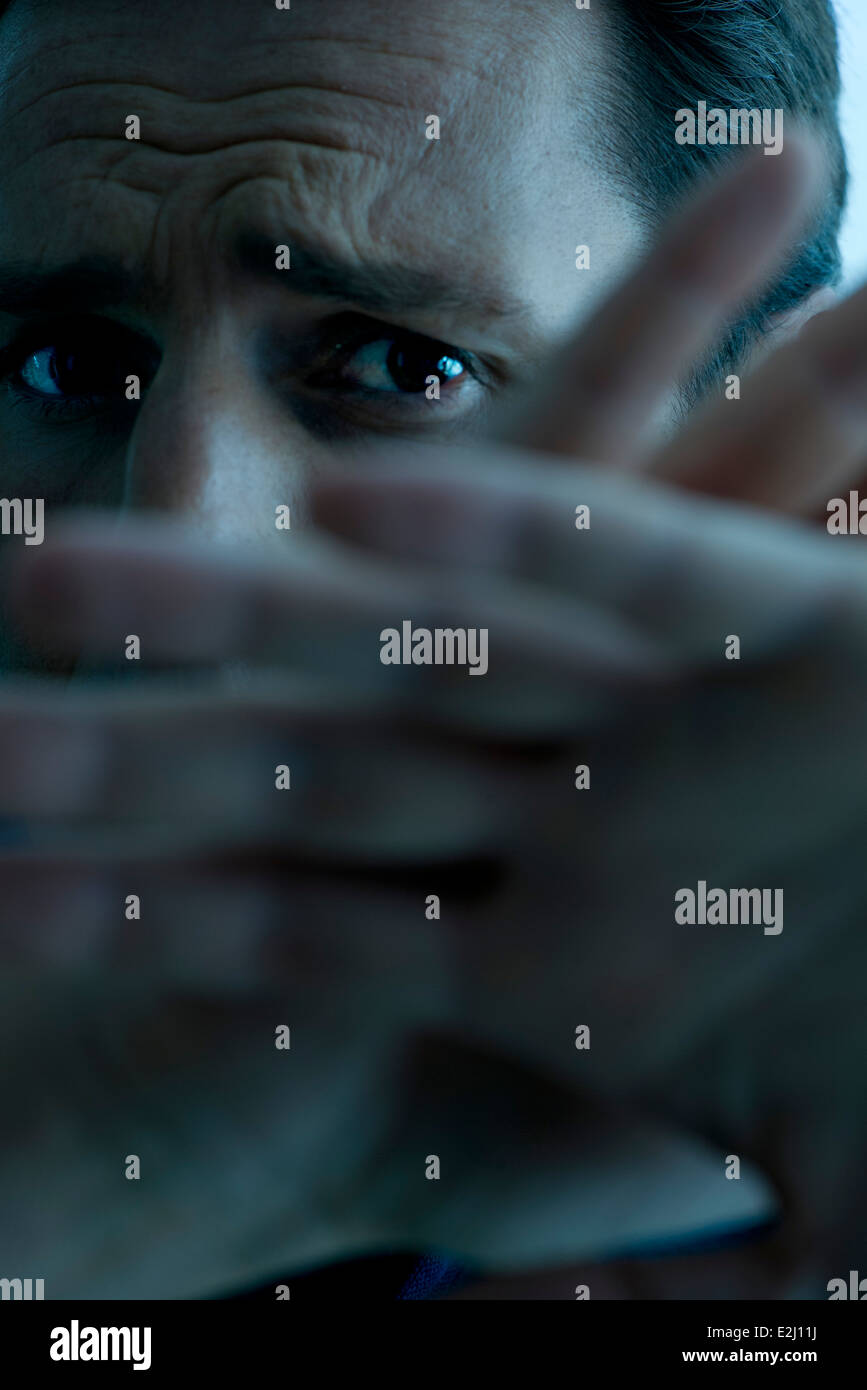 Uomo con le mani alzate scongiurare un attacco Foto Stock