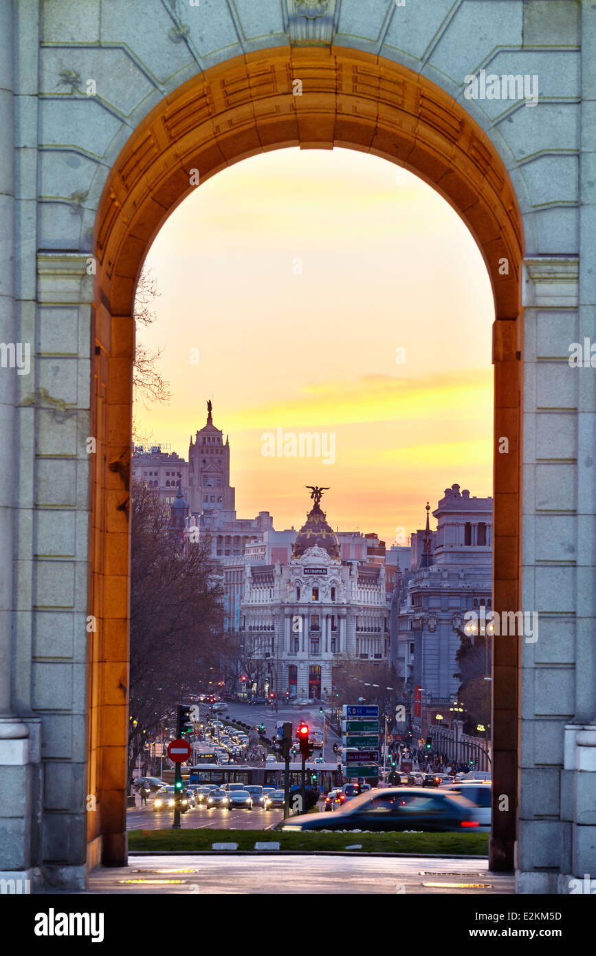 Il Metropolis palazzo visto attraverso "Puerta de Alcalá' monumento dal tramonto. Madrid, Spagna Foto Stock