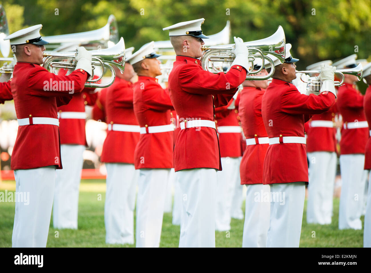 United States Marine Drum and Bugle Corps Arlington Virginia // ARLINGTON, Virginia — membri del United States Marine Drum and Bugle Corps, "The Commandant's Own", si esibiscono durante la Sunset Parade al Marine Corps War Memorial. L'unità musicale d'élite, fondata nel 1934, esegue movimenti di precisione mentre suona musica marziale tradizionale. L'iconico memoriale, raffigurante la bandiera che si innalza a Iwo Jima, funge da sfondo drammatico per queste cerimonie estive settimanali che si tengono il martedì sera. Le esibizioni mostrano la precisione del corpo dei Marines e lo sfarzo militare per il pubblico Foto Stock