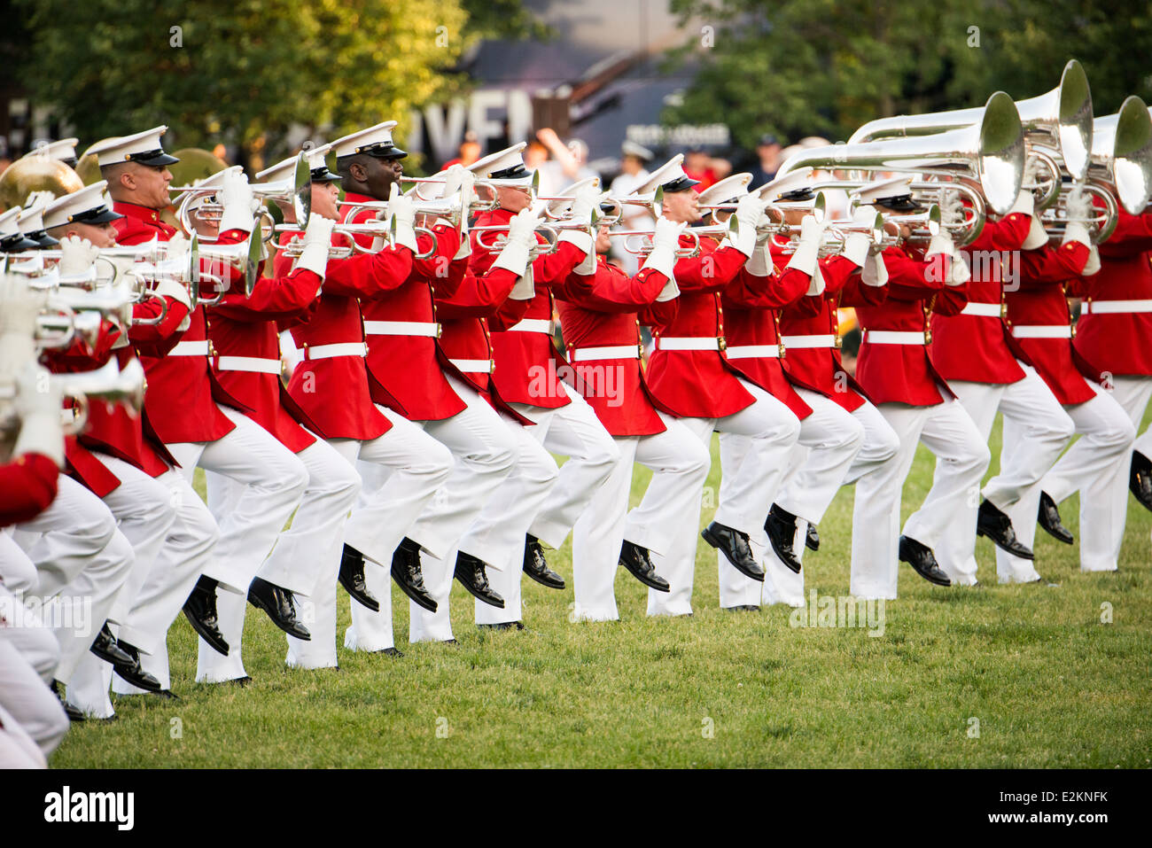 United States Marine Drum and Bugle Corps Arlington Virginia // ARLINGTON, Virginia — membri del United States Marine Drum and Bugle Corps, "The Commandant's Own", si esibiscono durante la Sunset Parade al Marine Corps War Memorial. L'unità musicale d'élite, fondata nel 1934, esegue movimenti di precisione mentre suona musica marziale tradizionale. L'iconico memoriale, raffigurante la bandiera che si innalza a Iwo Jima, funge da sfondo drammatico per queste cerimonie estive settimanali che si tengono il martedì sera. Le esibizioni mostrano la precisione del corpo dei Marines e lo sfarzo militare per il pubblico Foto Stock