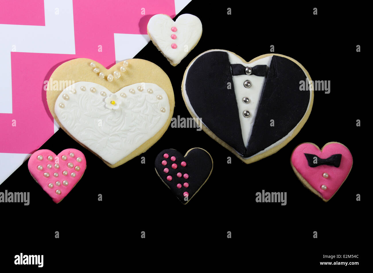 Il regalo di nozze favore forma di cuore i cookie sul moderno nero con rosa e bianco strisce chevron Foto Stock