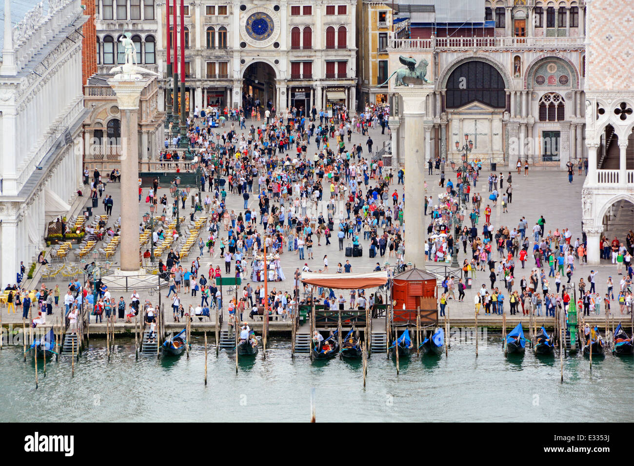 Vista verso il basso dalla nave da crociera con partenza da Venezia lungo il canale della Giudecca passando davanti al Palazzo Ducale occupato da turisti e gondole lungo il Molo Foto Stock
