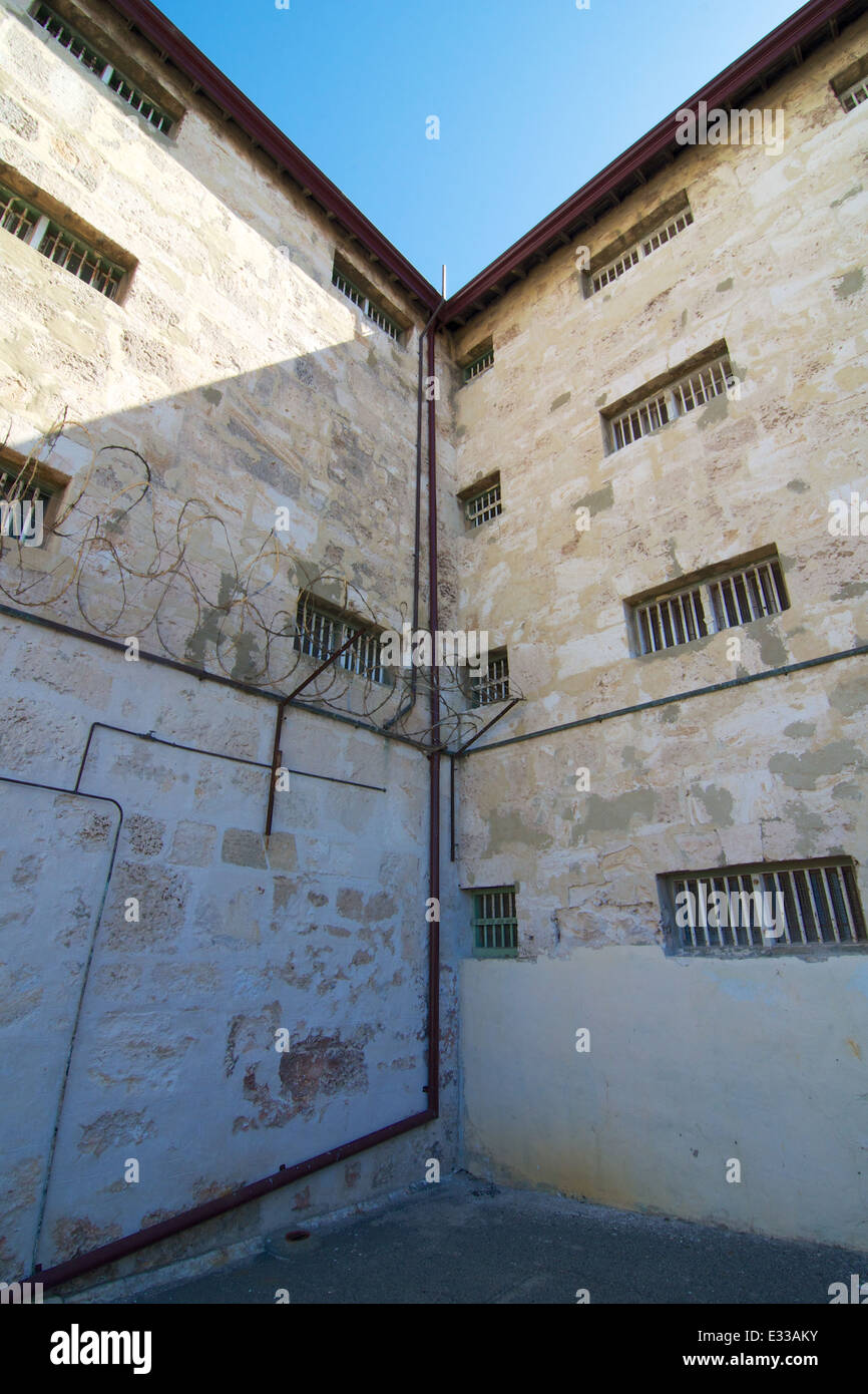 L'angolo interno delle due ali del patrimonio elencati Fremantle Prison. Il tiro mostra barre sulla cella windows e filo spinato. Foto Stock