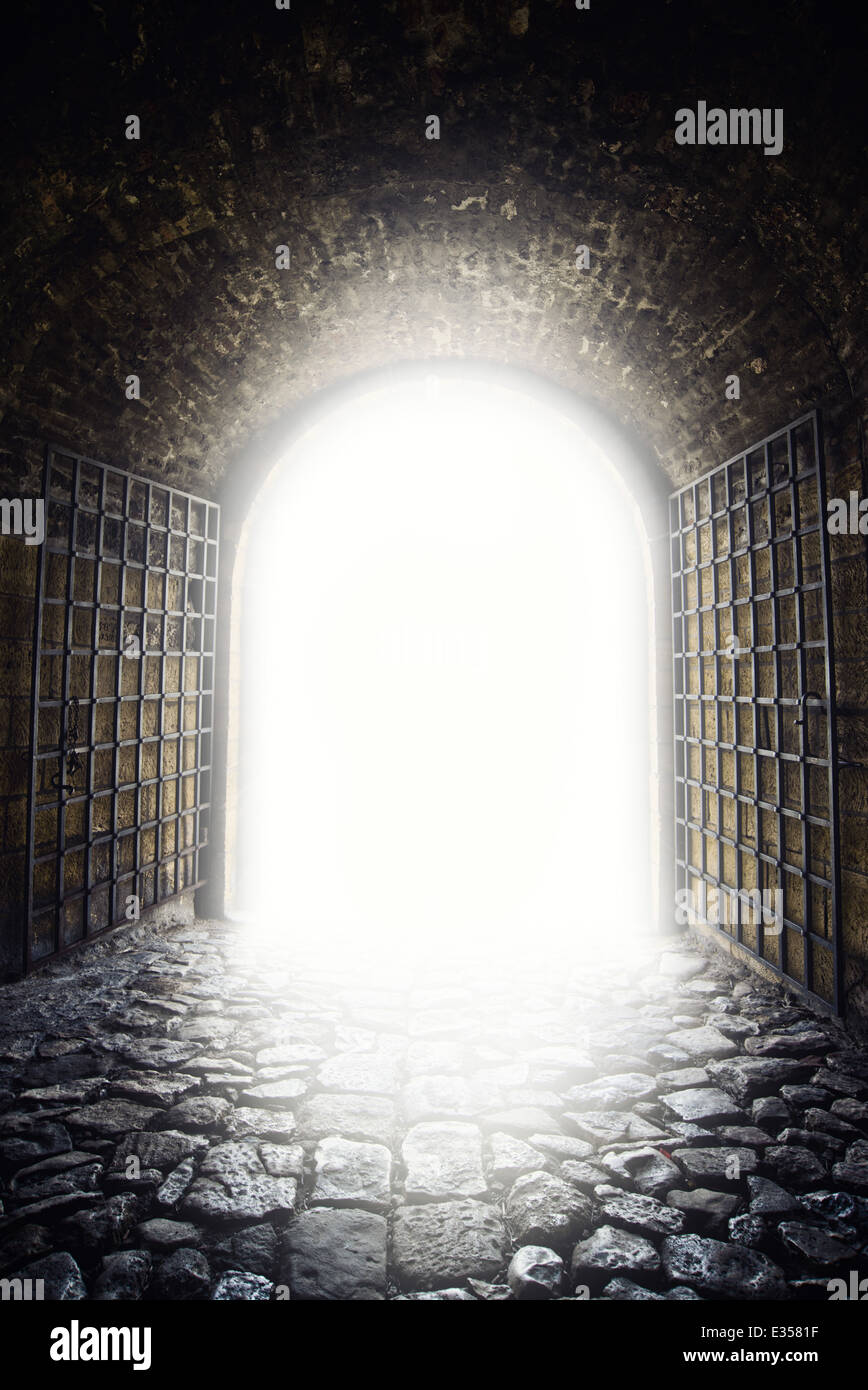 Uscire alla luce. La luce alla fine del tunnel come speranza metphor. Vecchio arco di apertura porta. Foto Stock