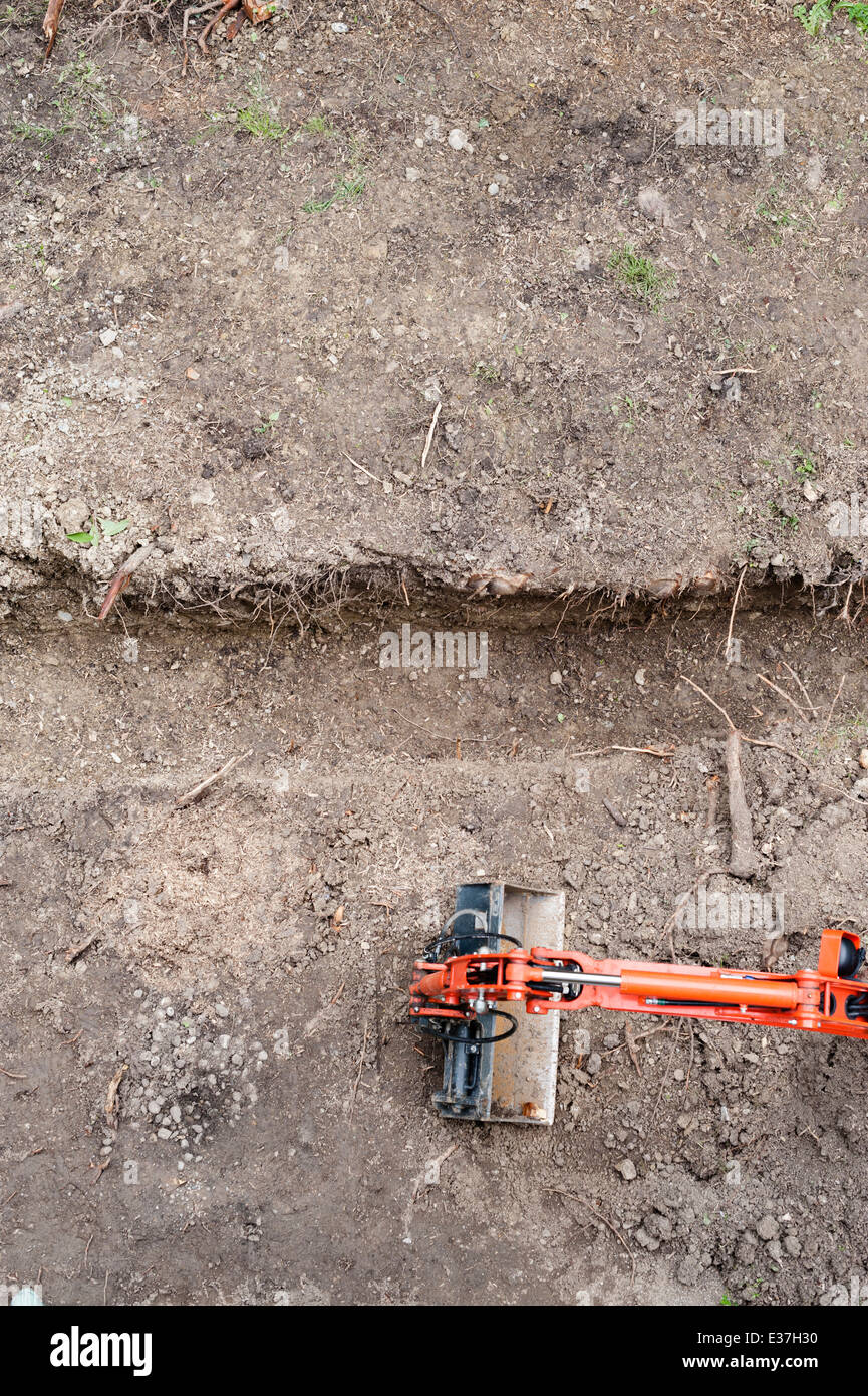 Topview della costruzione di un sito con la benna escavatore per attività di movimento terra Foto Stock