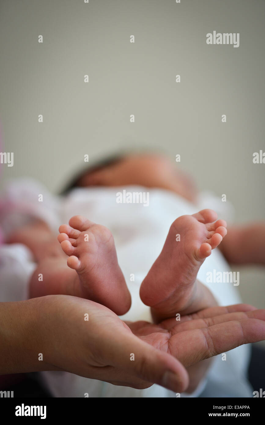 Il bambino neonato piedi preziosi su Madre la mano - Concetto di innocenza Foto Stock