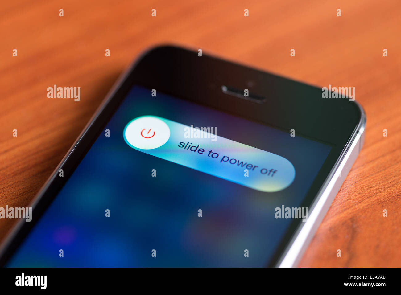 Nuovo Apple iPhone 5S con spegni l'opzione sullo schermo giacente su una scrivania Foto Stock