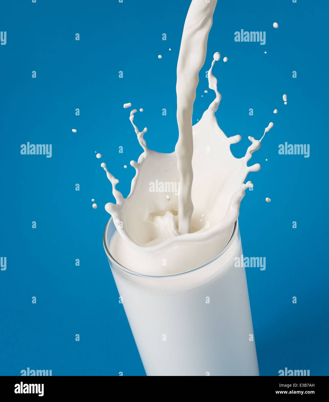 Versando un bicchiere di latte la creazione di splash Foto Stock
