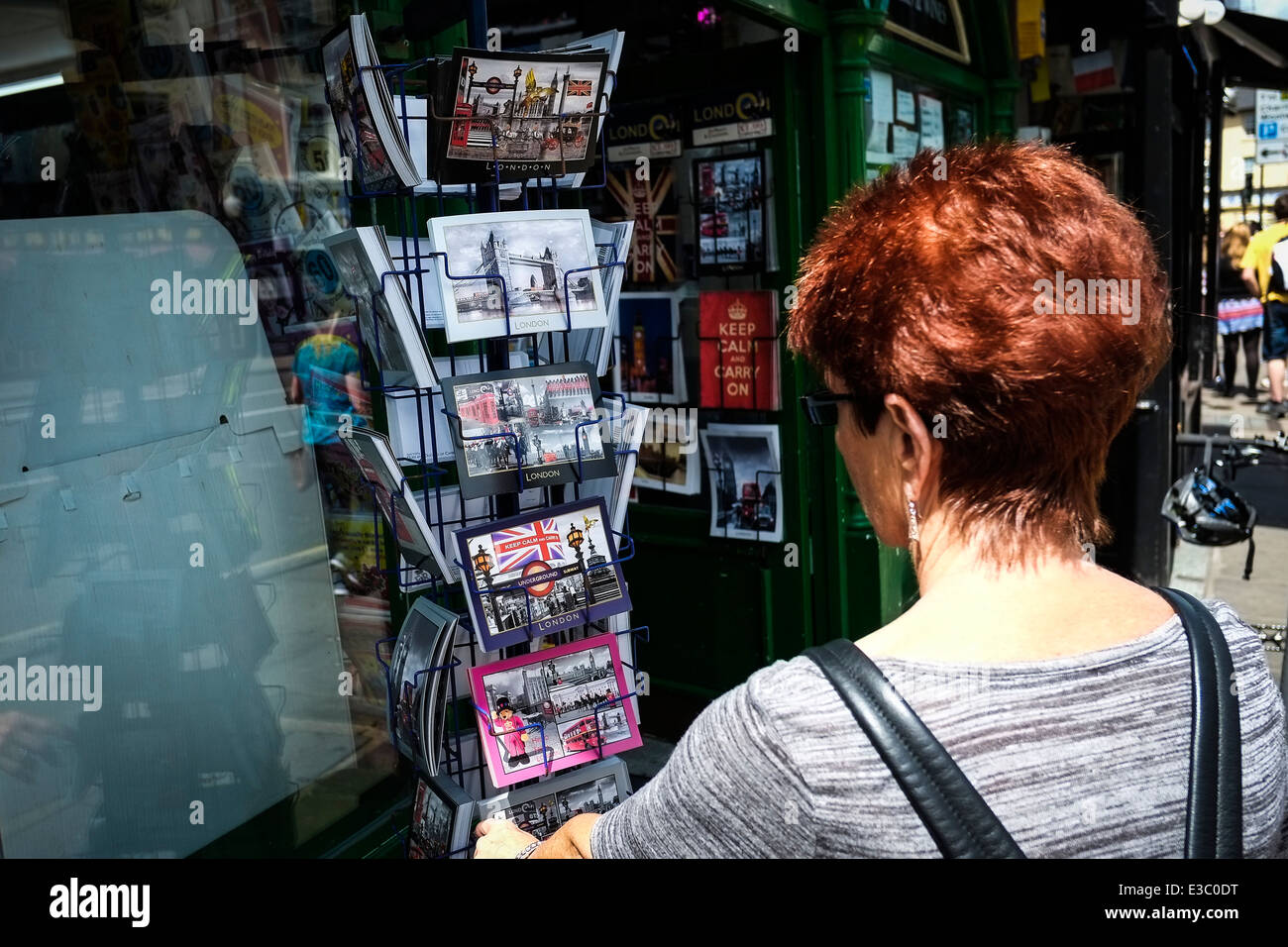 Un turista scegliendo una cartolina. Foto Stock