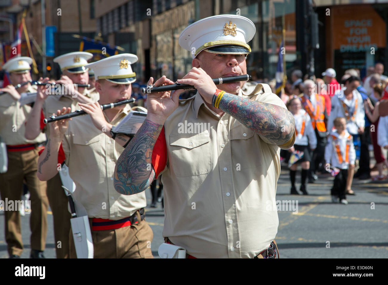 L'uomo suonare il flauto, prendendo parte a un Orange Walk sfilano per le strade di Glasgow, Scotland, Regno Unito Foto Stock