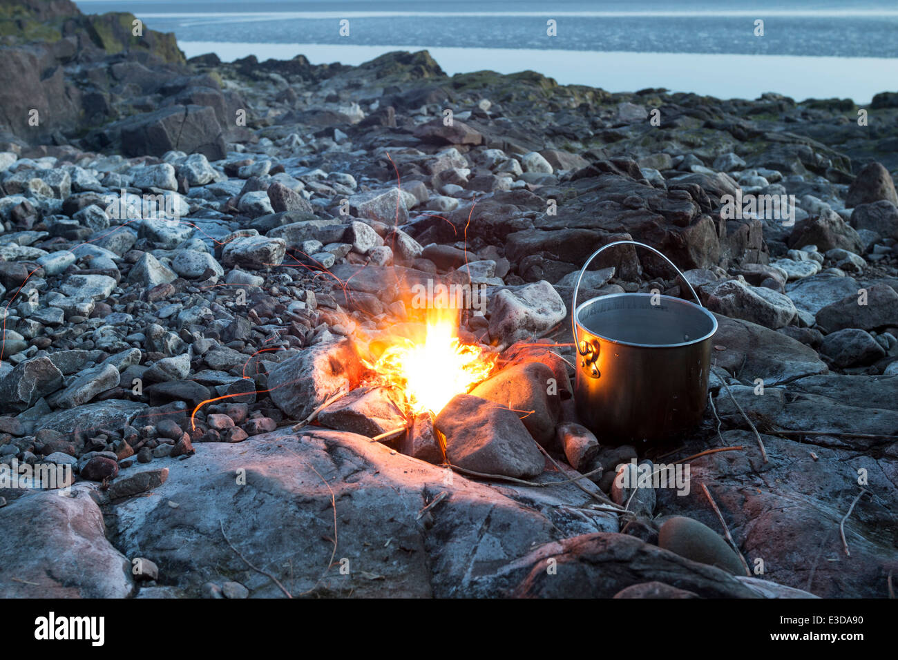 Il fuoco con il recipiente di cottura su una spiaggia rocciosa England Regno Unito Foto Stock