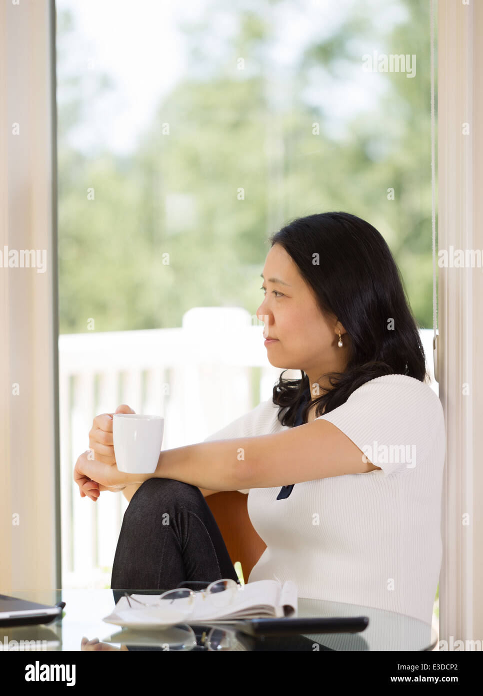 L'immagine verticale di donna matura rilassante mentre si lavora da casa con offuscata dalla luce proveniente da una finestra in background Foto Stock