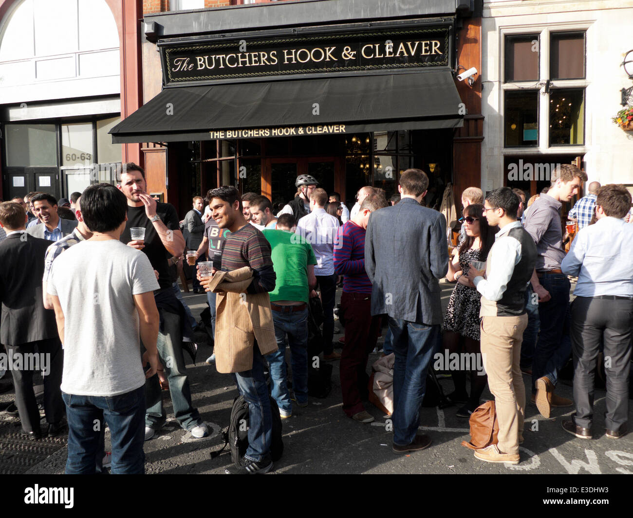 Colleghi di lavoro avente una birra sul marciapiede fuori i macellai gancio & Cleaver pub vicino a St Barts Hospital di Londra KATHY DEWITT Foto Stock