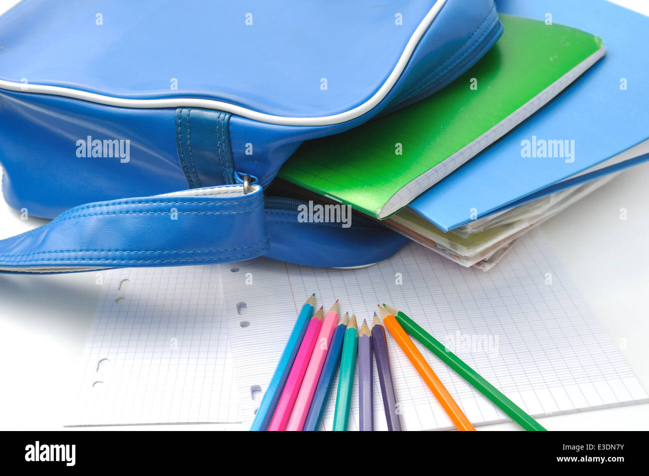 Matite, carta e materiali di consumo scuola in un libro borsa su sfondo bianco Foto Stock