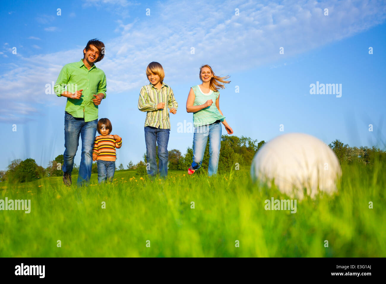 La famiglia felice gioca a calcio in estate Foto Stock