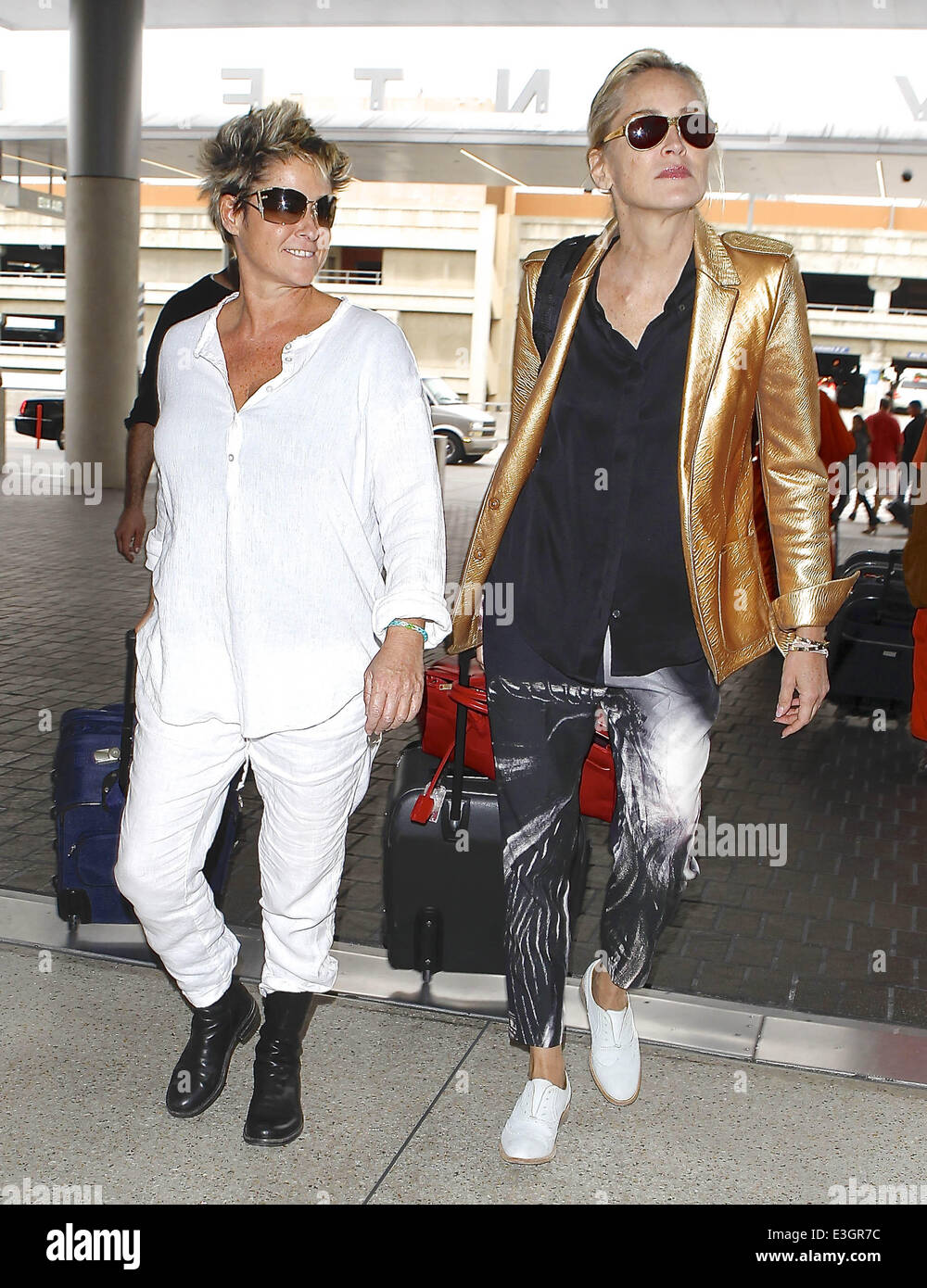 'Basic Instinct' attrice Sharon Stone si allontana dal LAX con un amico, indossando un color rame giacca, pantaloni stampati e scarpe di bianco. Dotato di: Sharon Stone dove: Los Angeles, California, Stati Uniti quando: 12 Nov 2013 Foto Stock