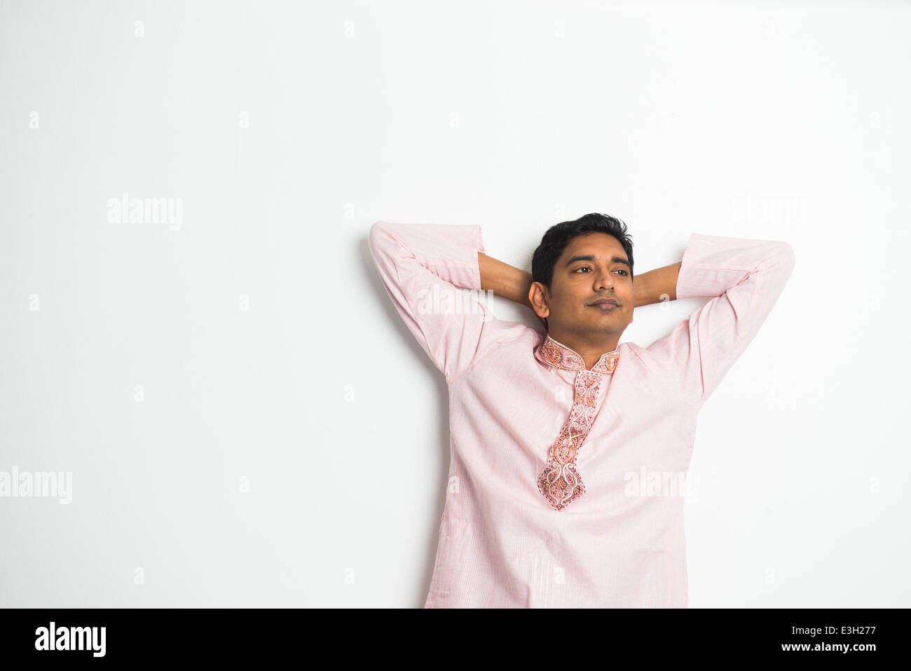 Giovane uomo indiano con posa rilassata e abito tradizionale Foto Stock