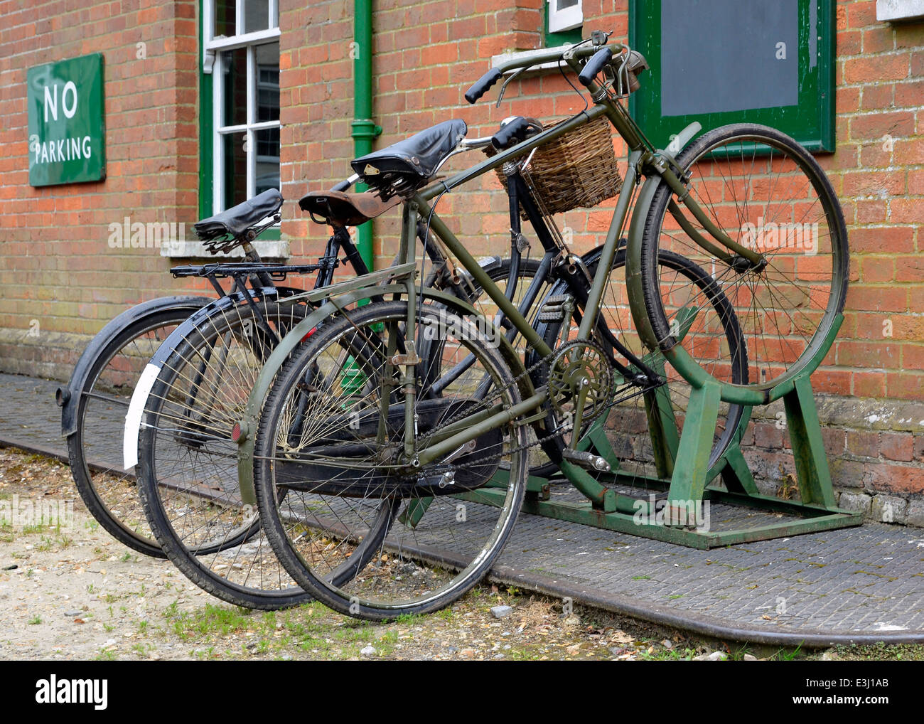 Le biciclette degli anni trenta e quaranta in un rack di ciclo al di fuori di un paese stazione ferroviaria durante un WW2 evento. Foto Stock