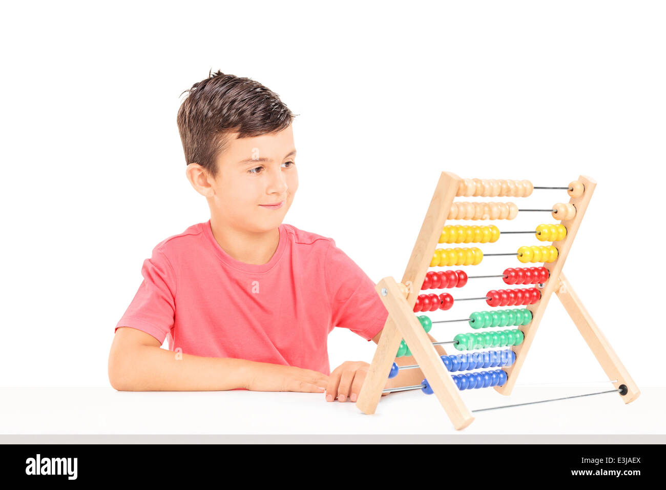 Little Boy conta su abacus seduti a un tavolo Foto Stock