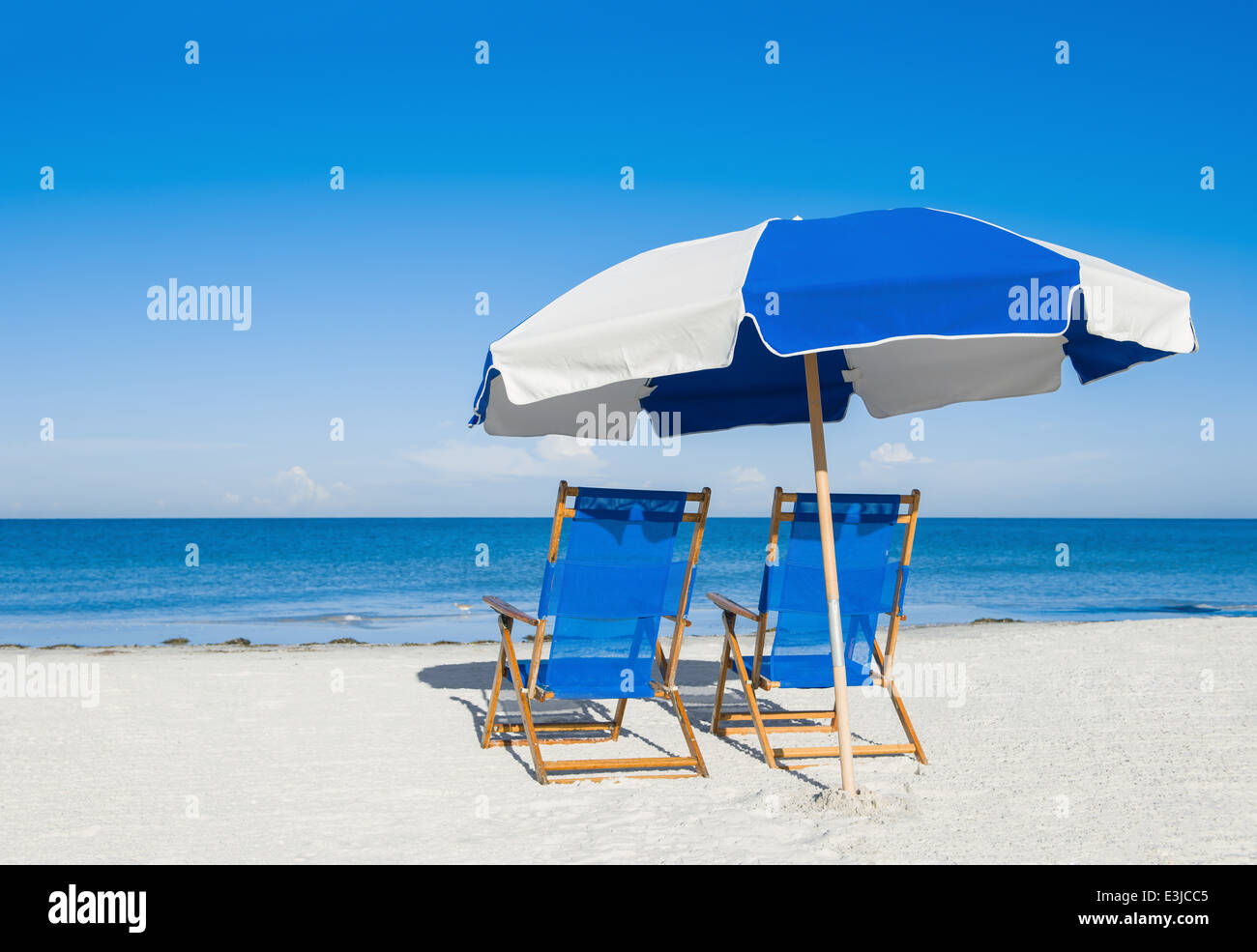 Sedie a sdraio e un ombrellone sulla sabbia di argento, concetto di vacanza Foto Stock