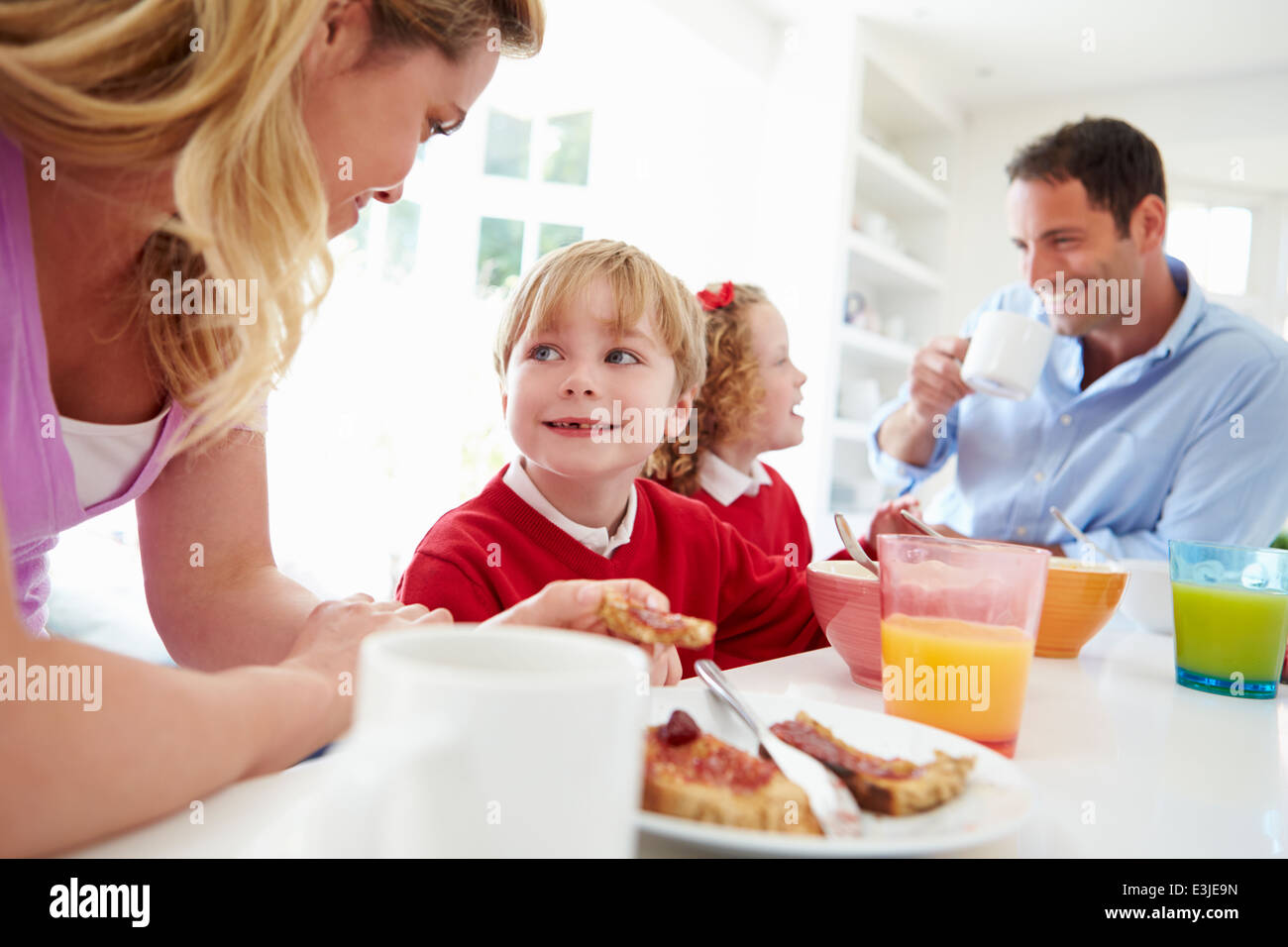 Famiglia con prima colazione in cucina prima della scuola Foto Stock