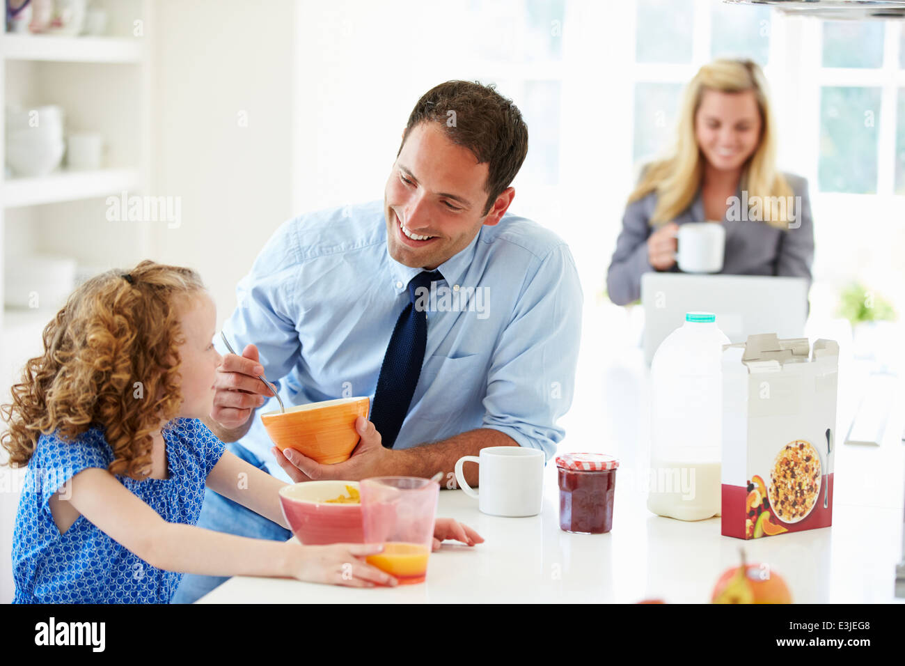 I genitori e la figlia avente la colazione nella cucina insieme Foto Stock
